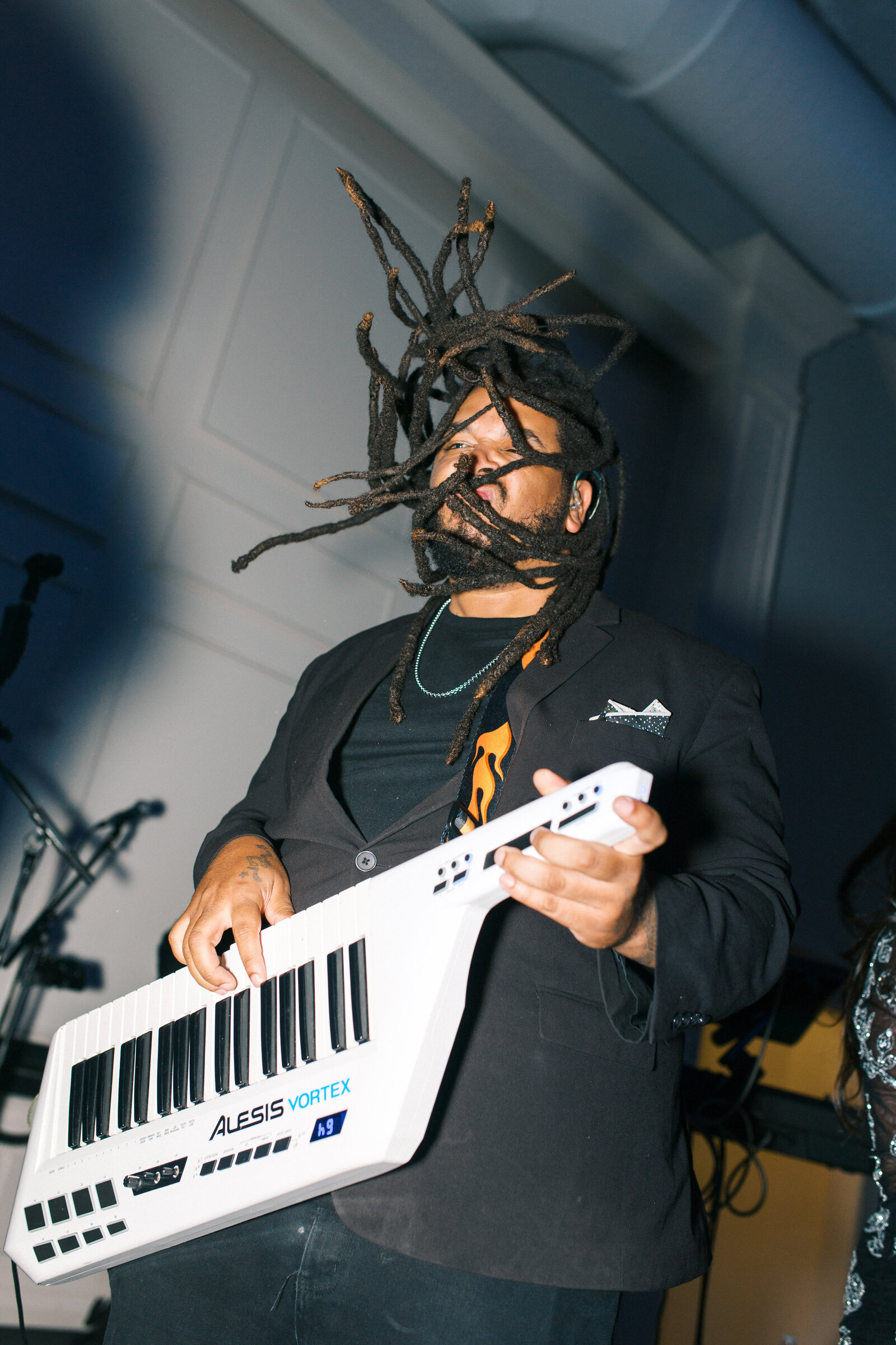 Wedding band Keyboard player with dreadlocks throwing head and playing keyboard at reception