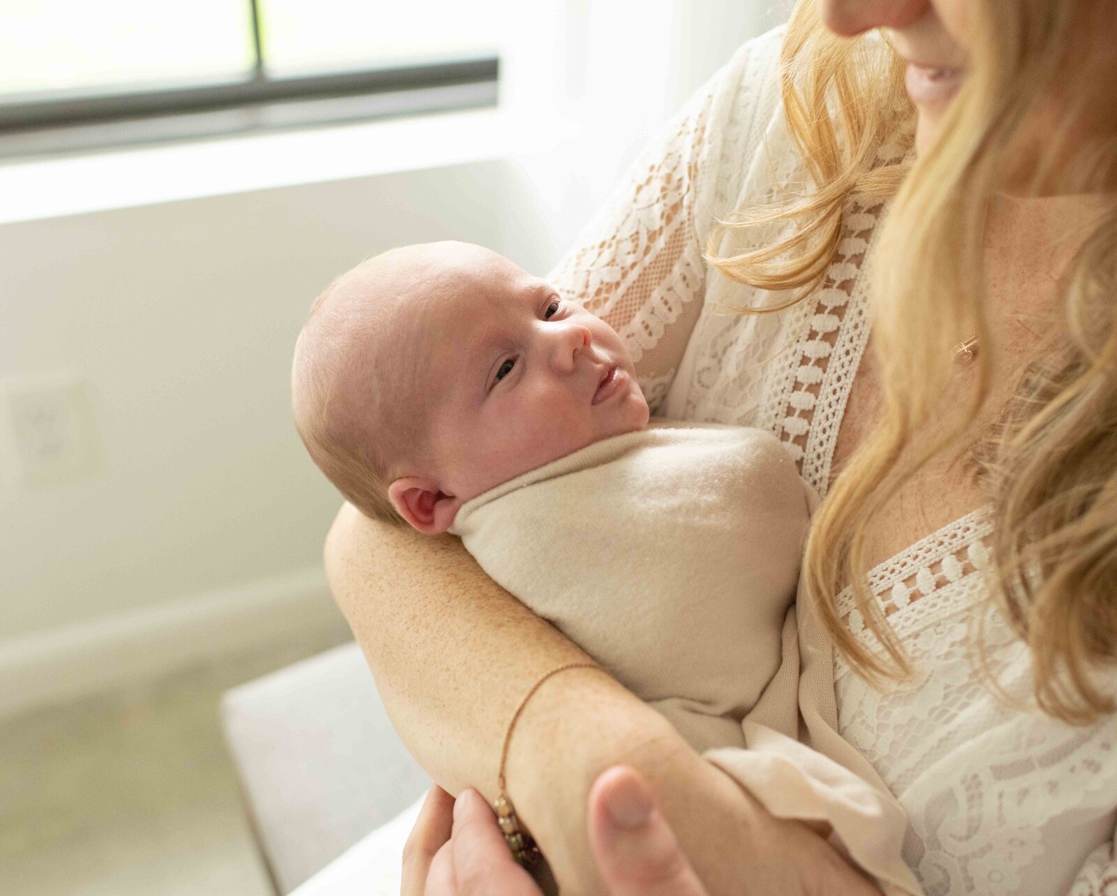 mother cradling newborn baby sleeping in her arms