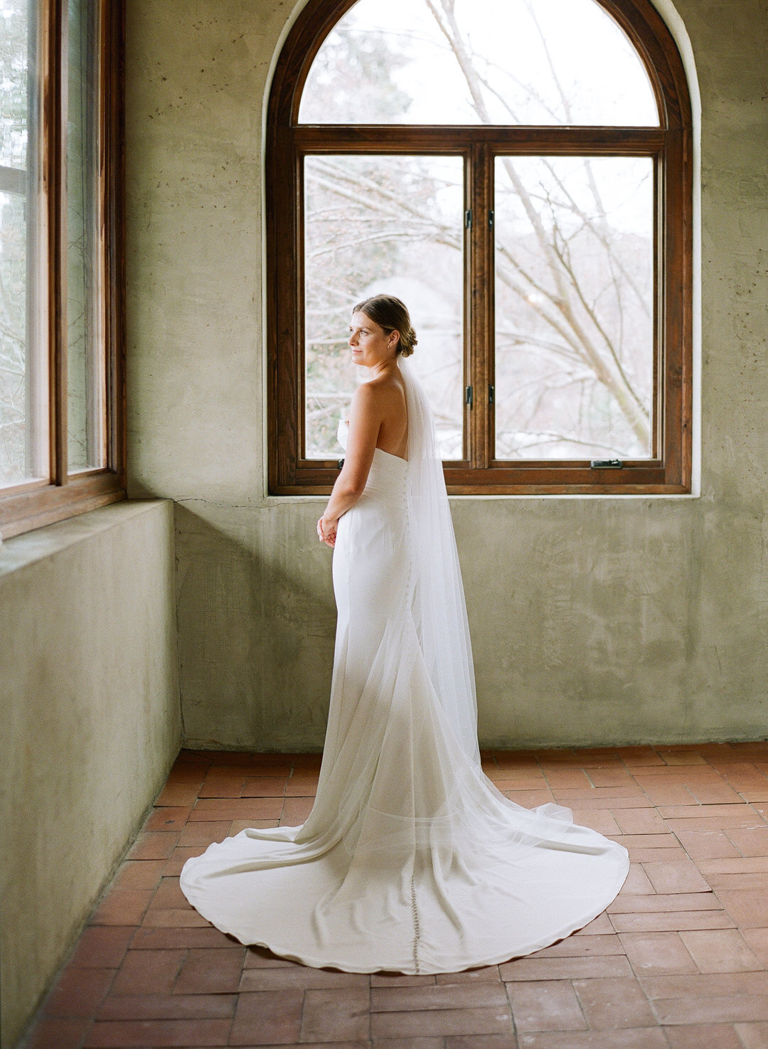 Bride in front of window looking out at Summerour in Atlanta