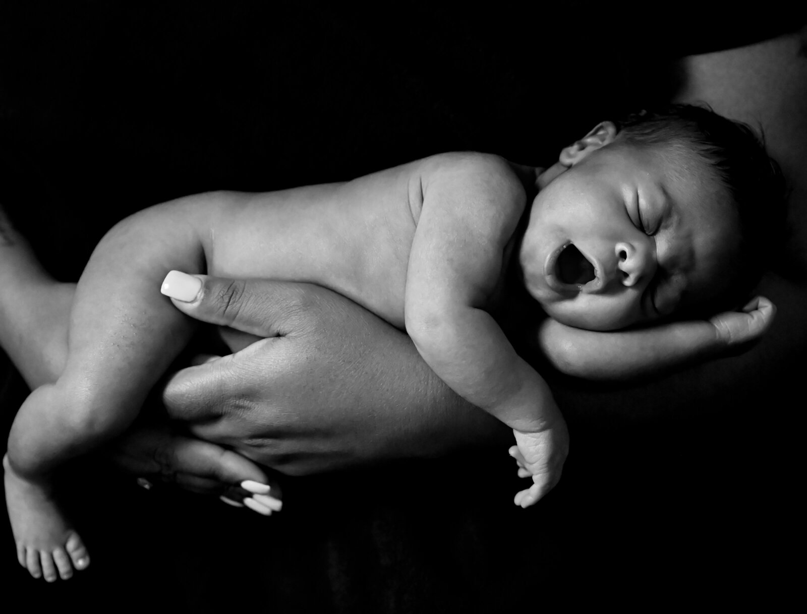 mother holding her yawning newborn baby photographed by Millz Photography in Greenville, SC