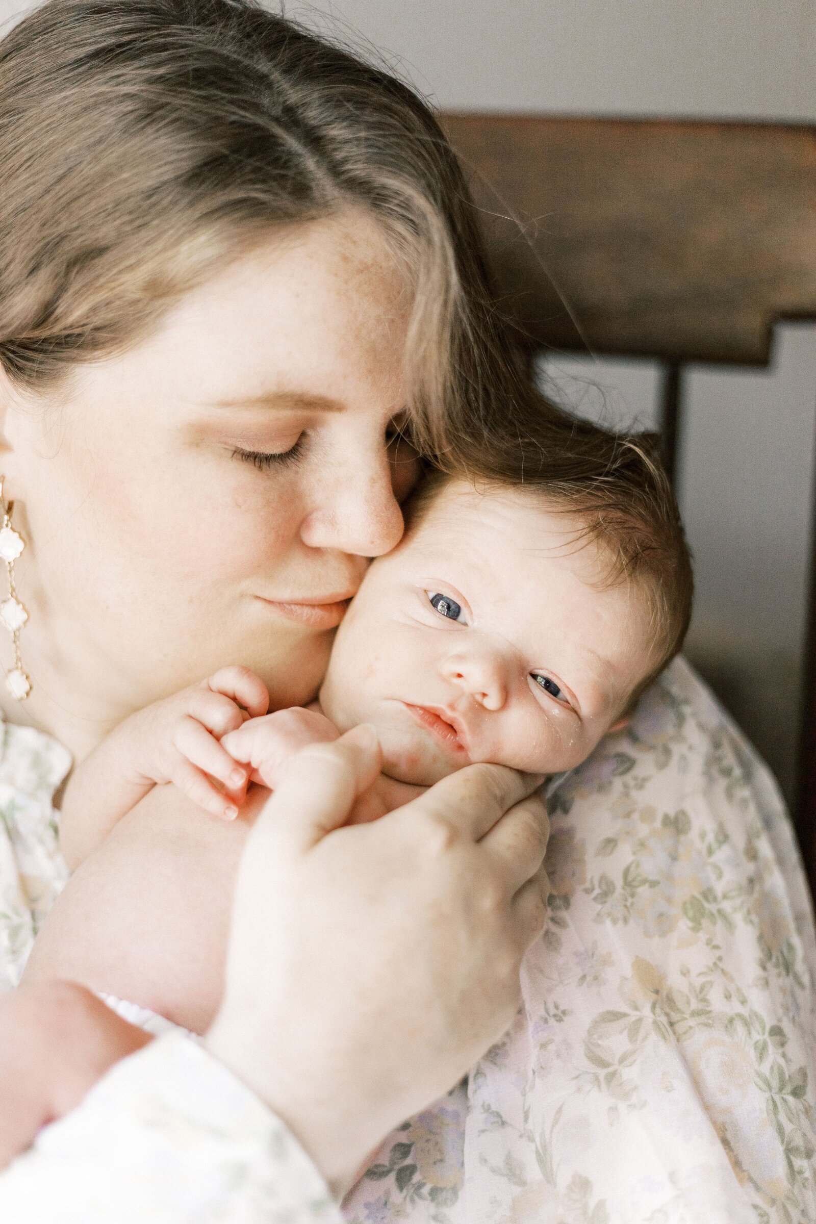 mom kissing newborn baby on cheek in peoria illinois newborn photos 