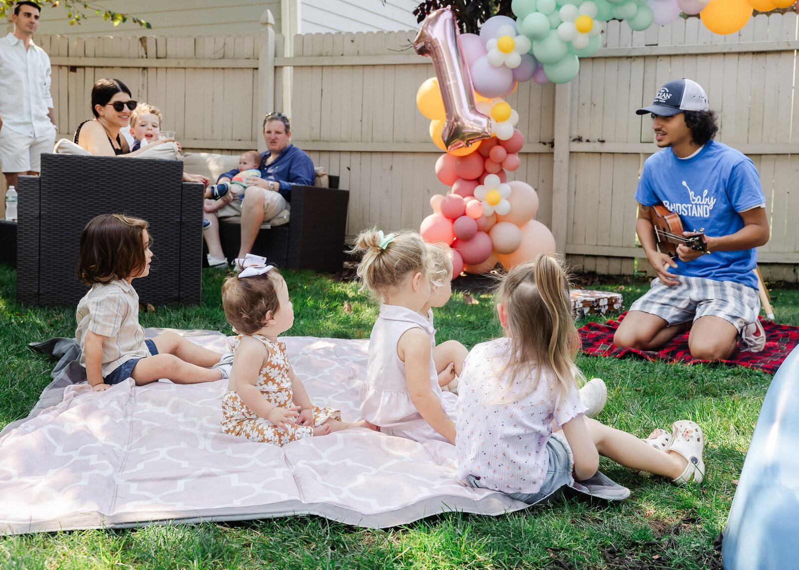 Kids watch a musician at a first birthday party