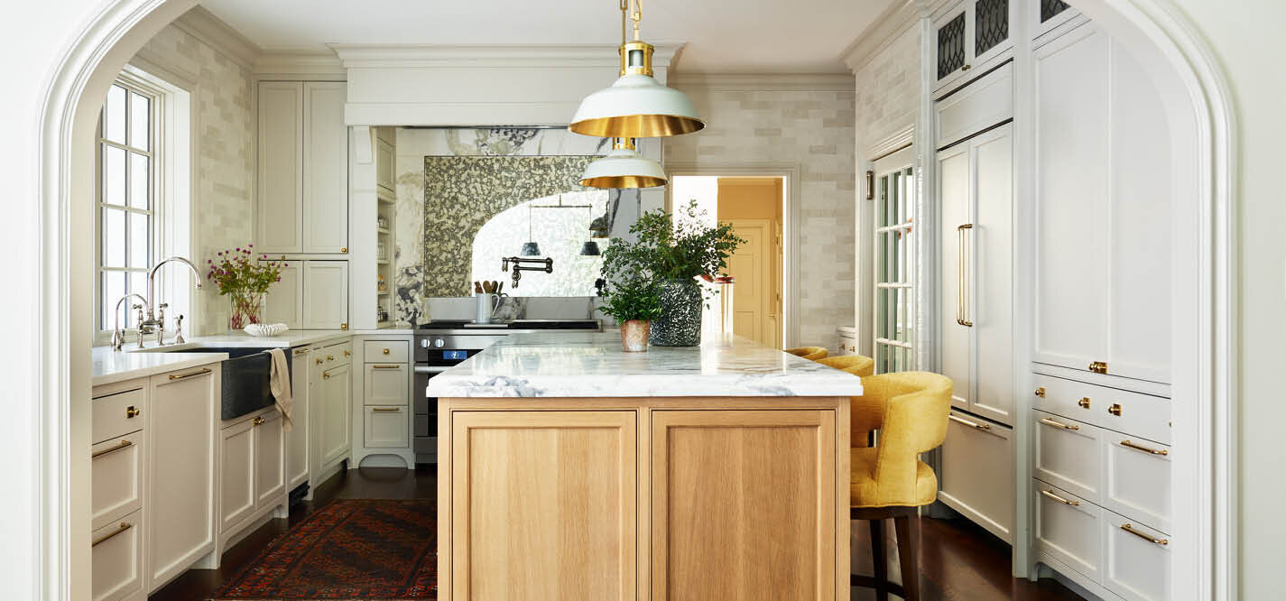 Explore the stunning transformation of a 90s era kitchen from dark and dated to light and airy. This reconfigured space features added windows, a new light oak island, and painted perimeter cabinets. Highlights include an alcove range, floor-to-ceiling tile, and traditional details for a classic, timeless look.
