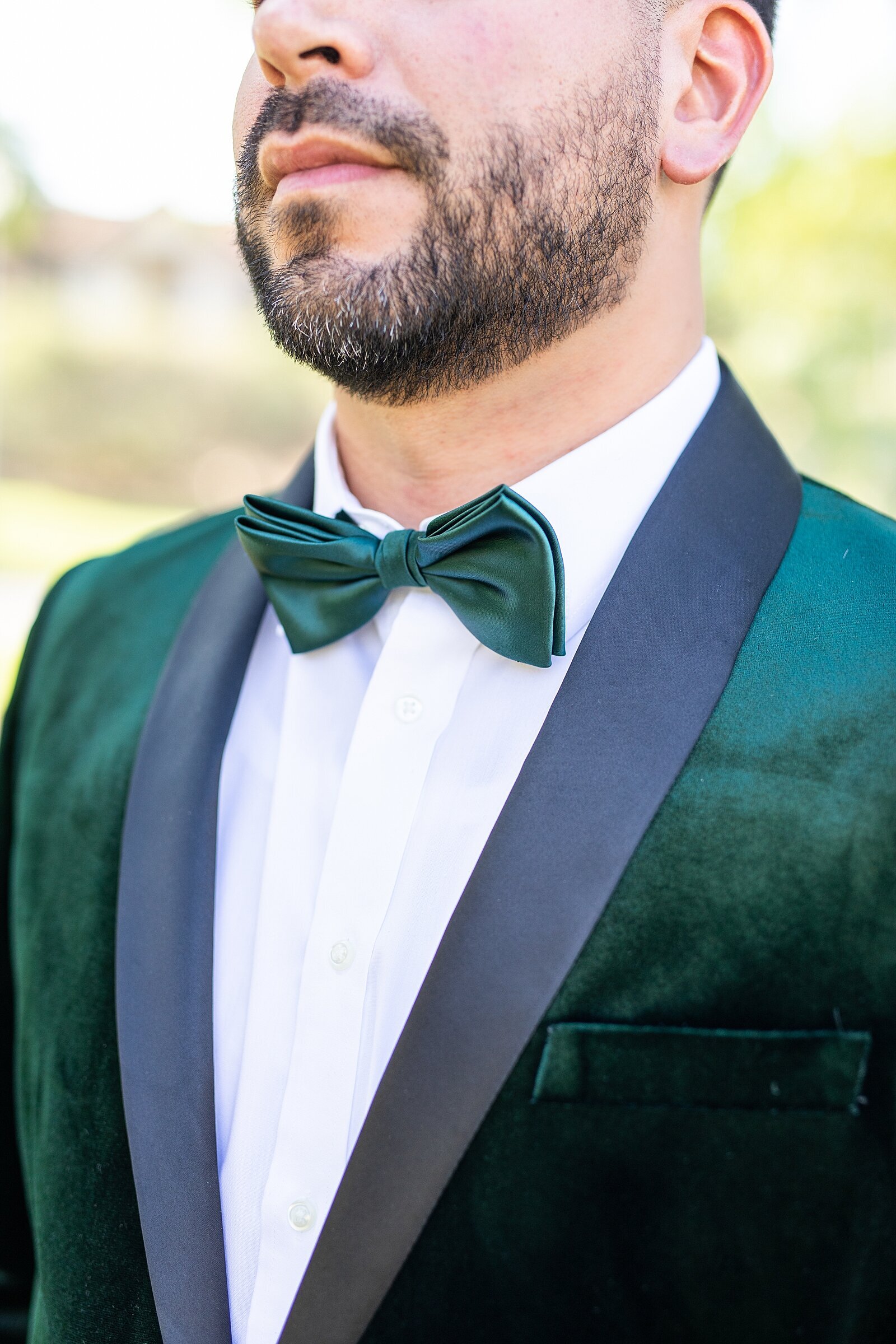 Groom wearing emerald suit and bowtie at Hummingbird Nest Wedding Venue in Santa Susana, California. | Sherr Weddings