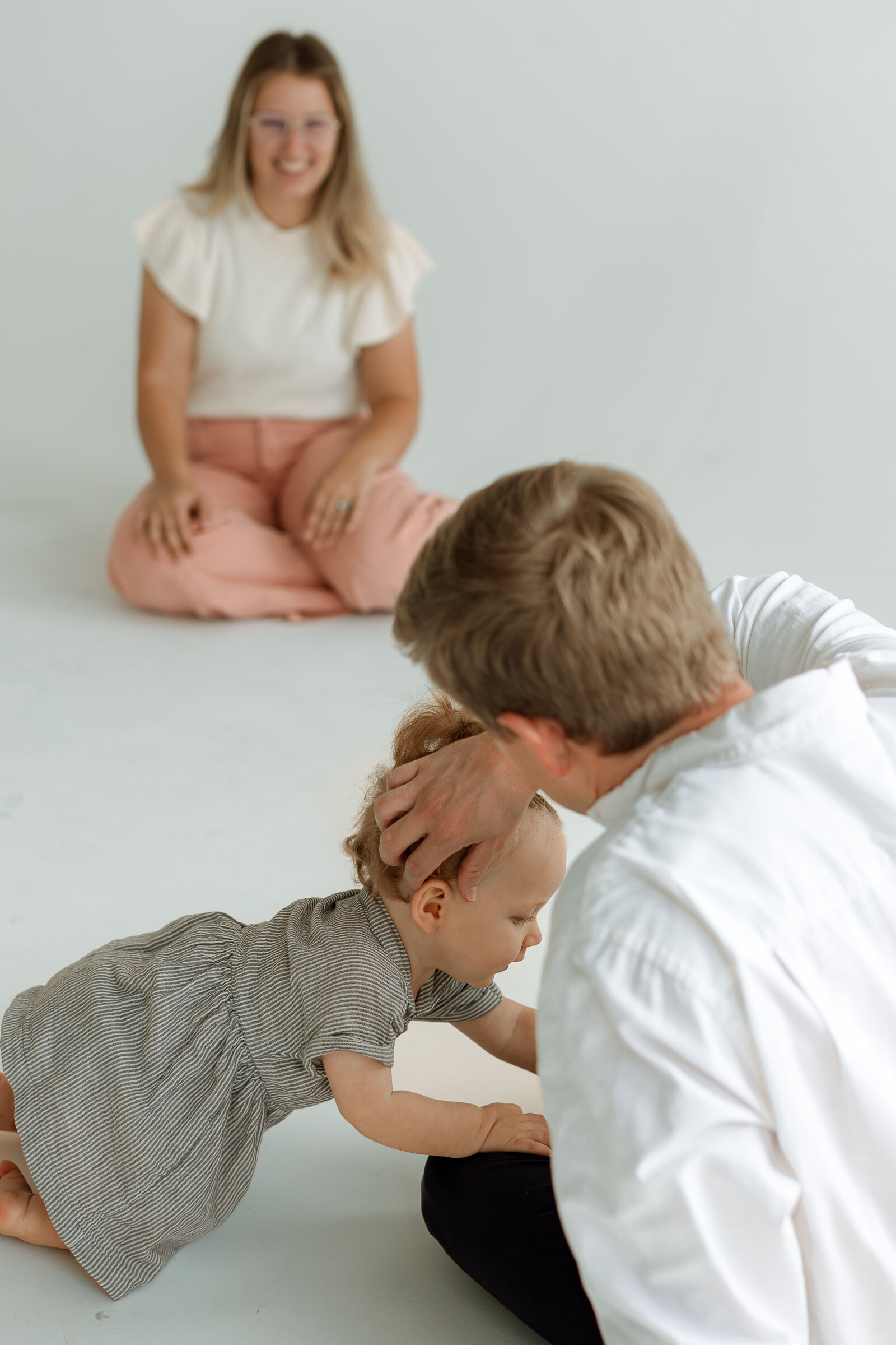 daughter crawling between mom and dad
