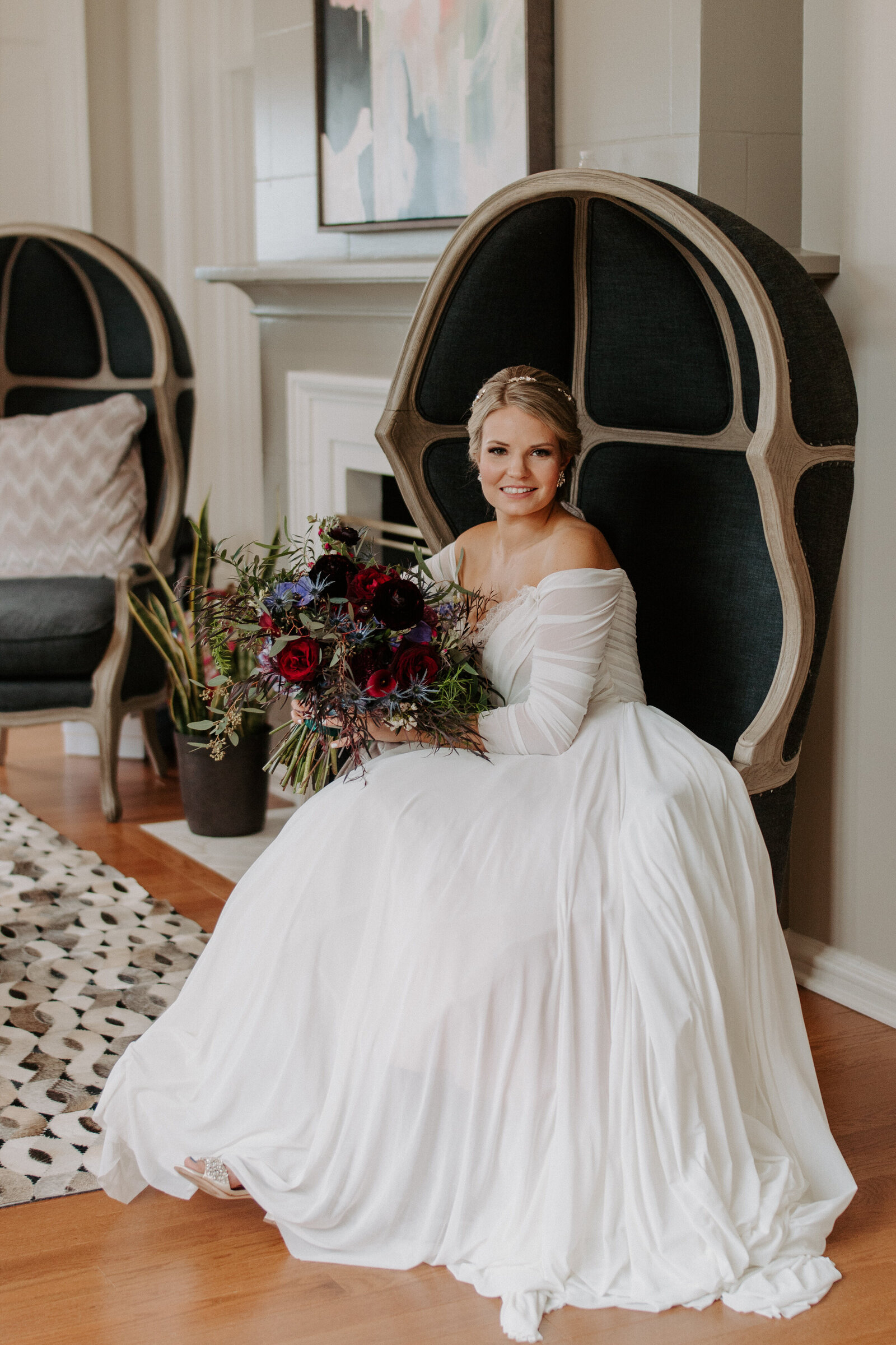 bride in a large white dress holding a bouquet of flowers while sitting down