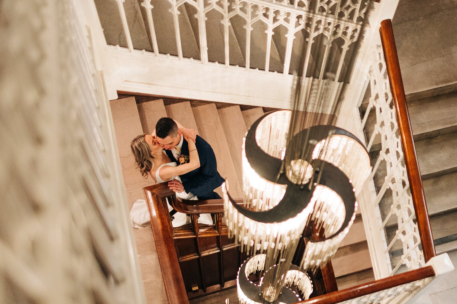 Bride kisses groom under the chandelier at Hotel Kansas City