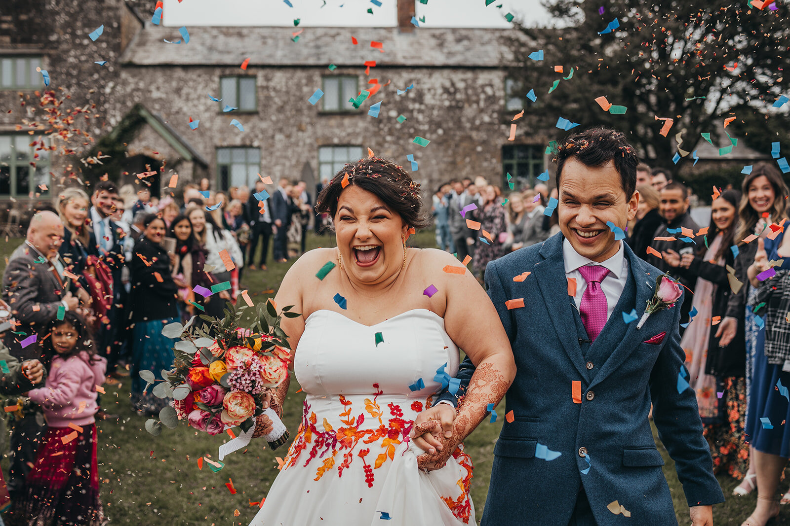 bride and groom get showered in confetti