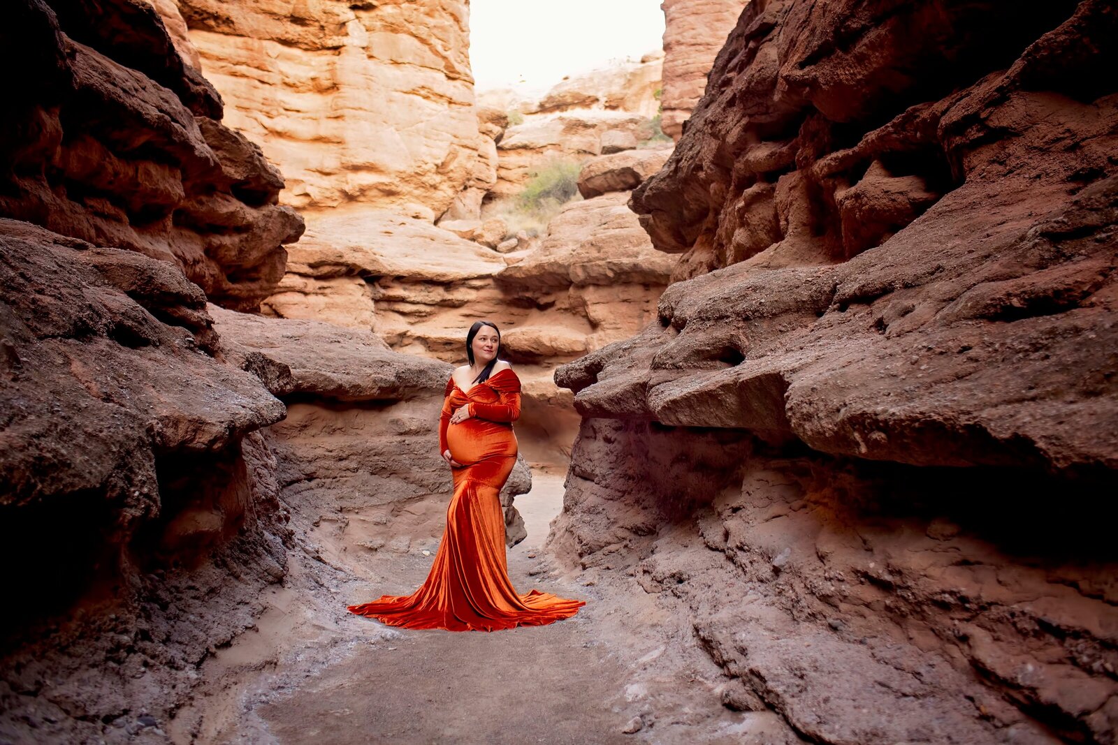 ABQ-slot-canyon-maternity-session-woman-in-a-orange-dress-in-a-slot-canyon