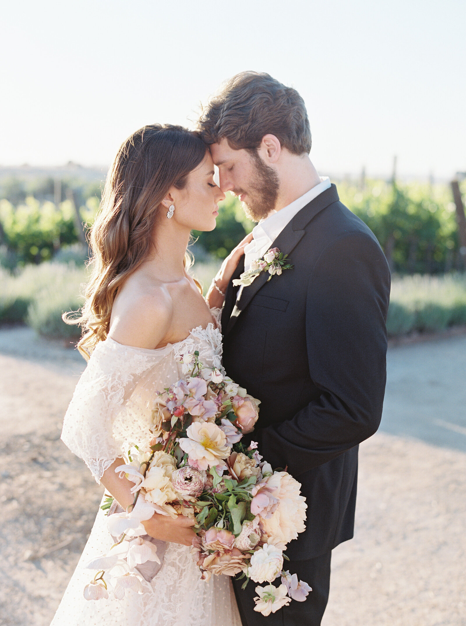 bride and groom touching four heads and holding each other close