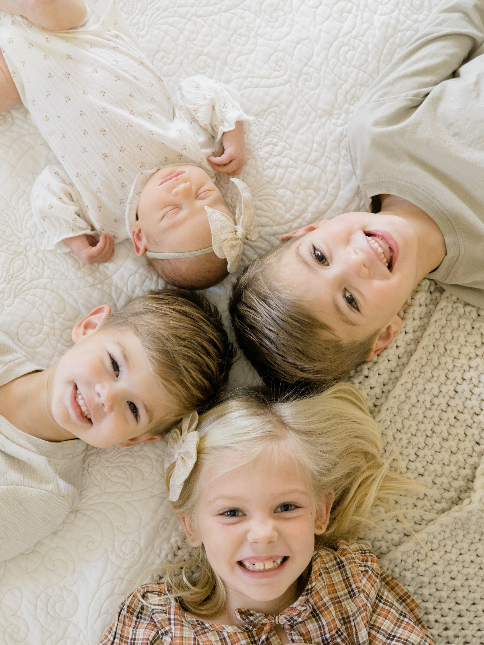 siblings laying on the floor and smiling up at the camera
