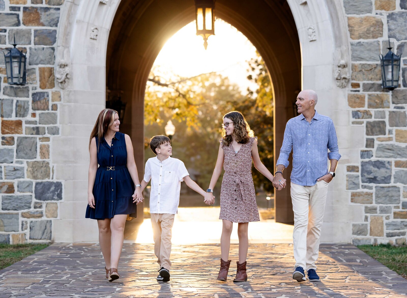 Family holding hands and walking under arches at Berry College. Rome photographer at Berry College - Jenni Nikki Photography.