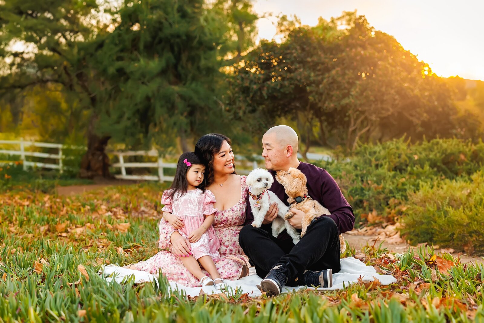 Family of 3 with their pets posing for a family portrait at Jack's Pond Park in San Marcos  in north county San Diego