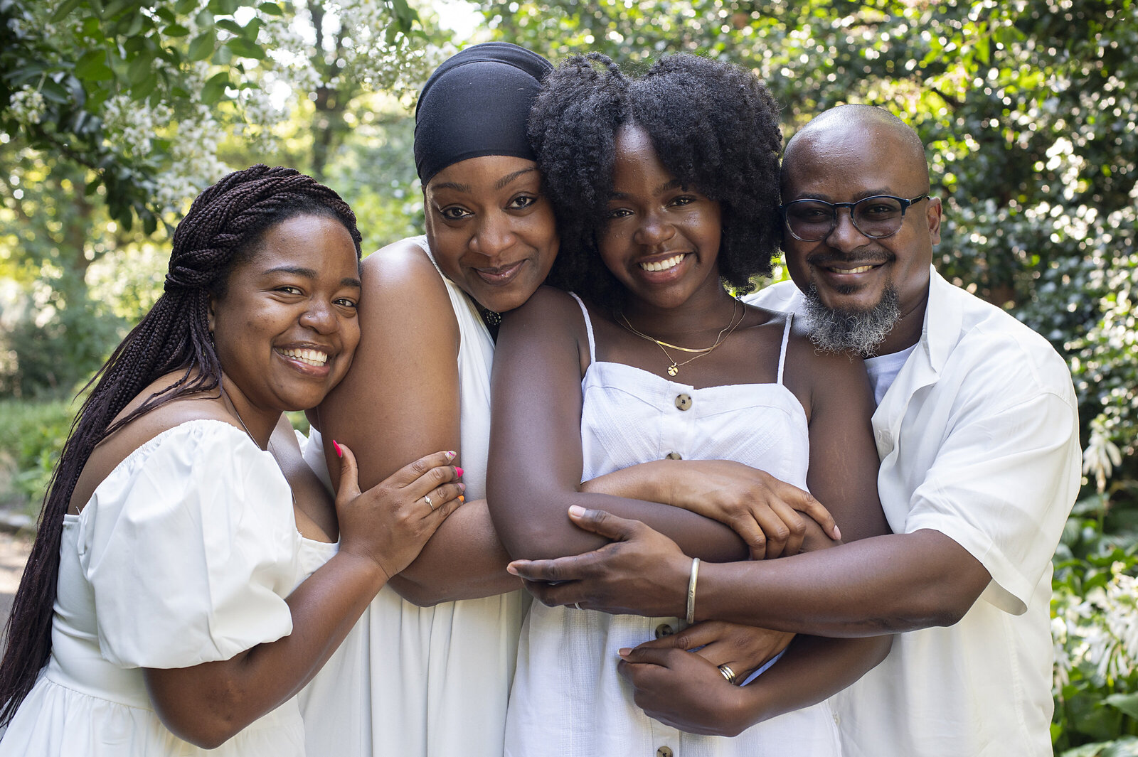 A family of four hugging each other and smiling 