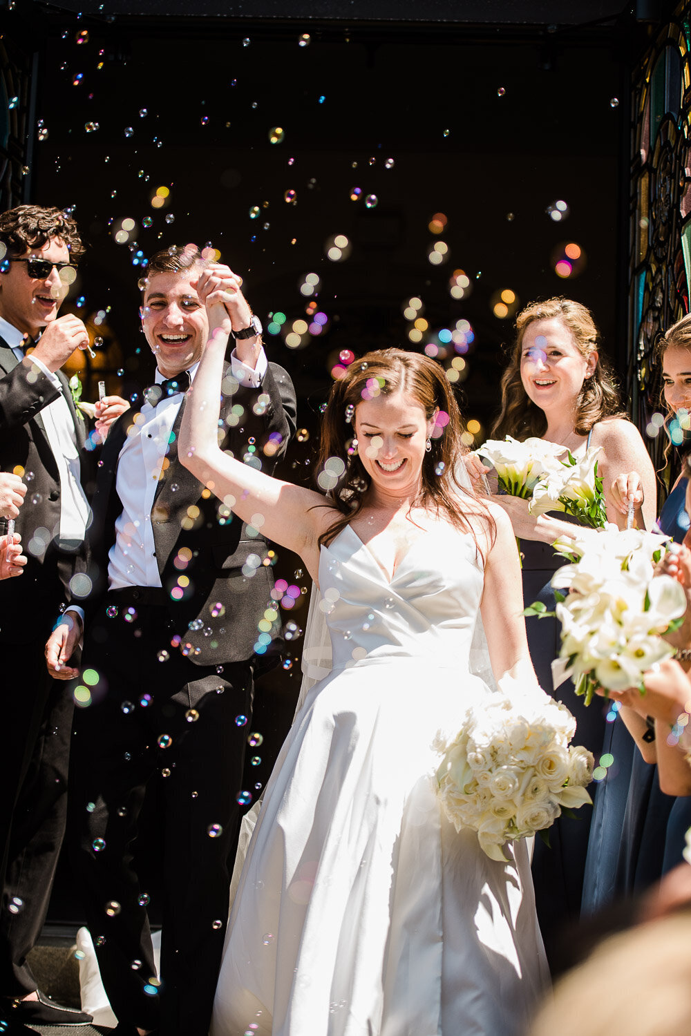 bride and groom exit church with bubbles