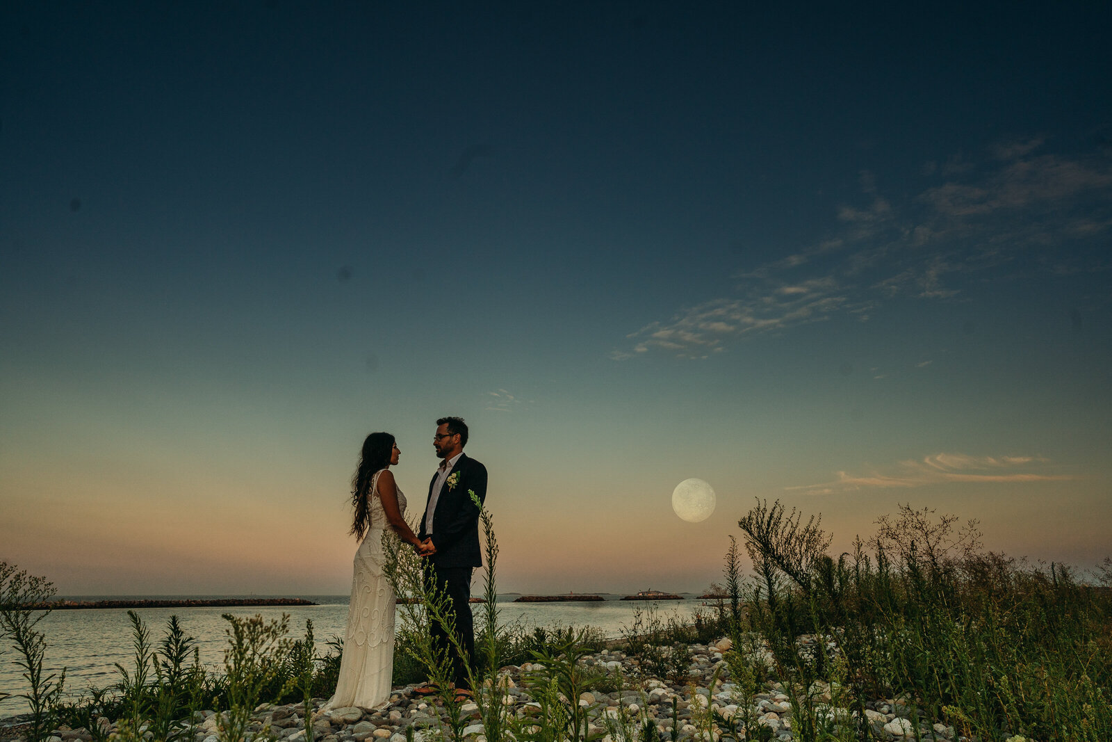 couple stands under moonlit sky