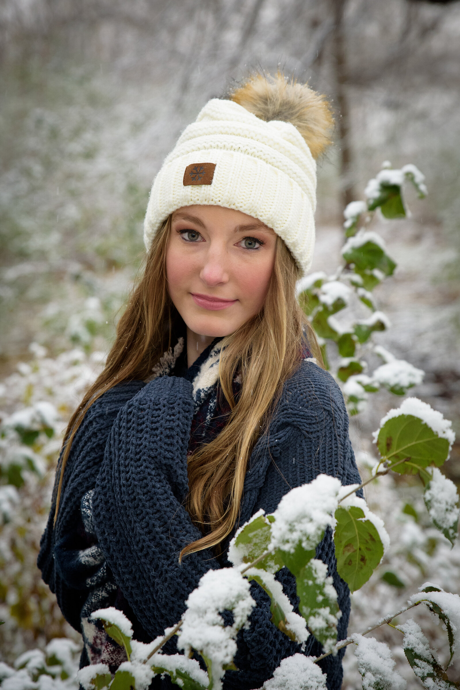 Senior girl wearing winter hat with a snowy background in Green Bay, Wisconsin