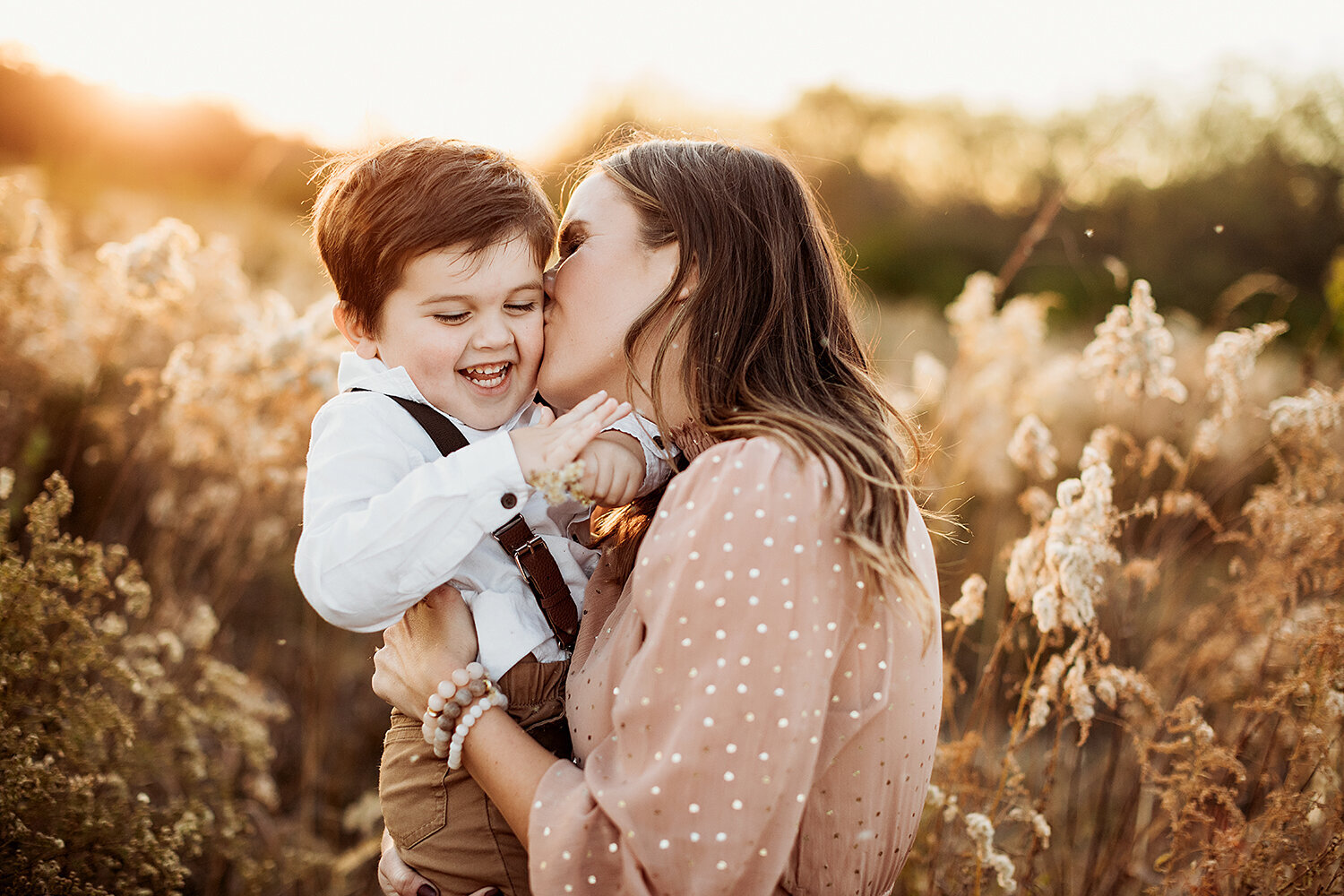 Family photography, mother kissing toddler son on his cheek