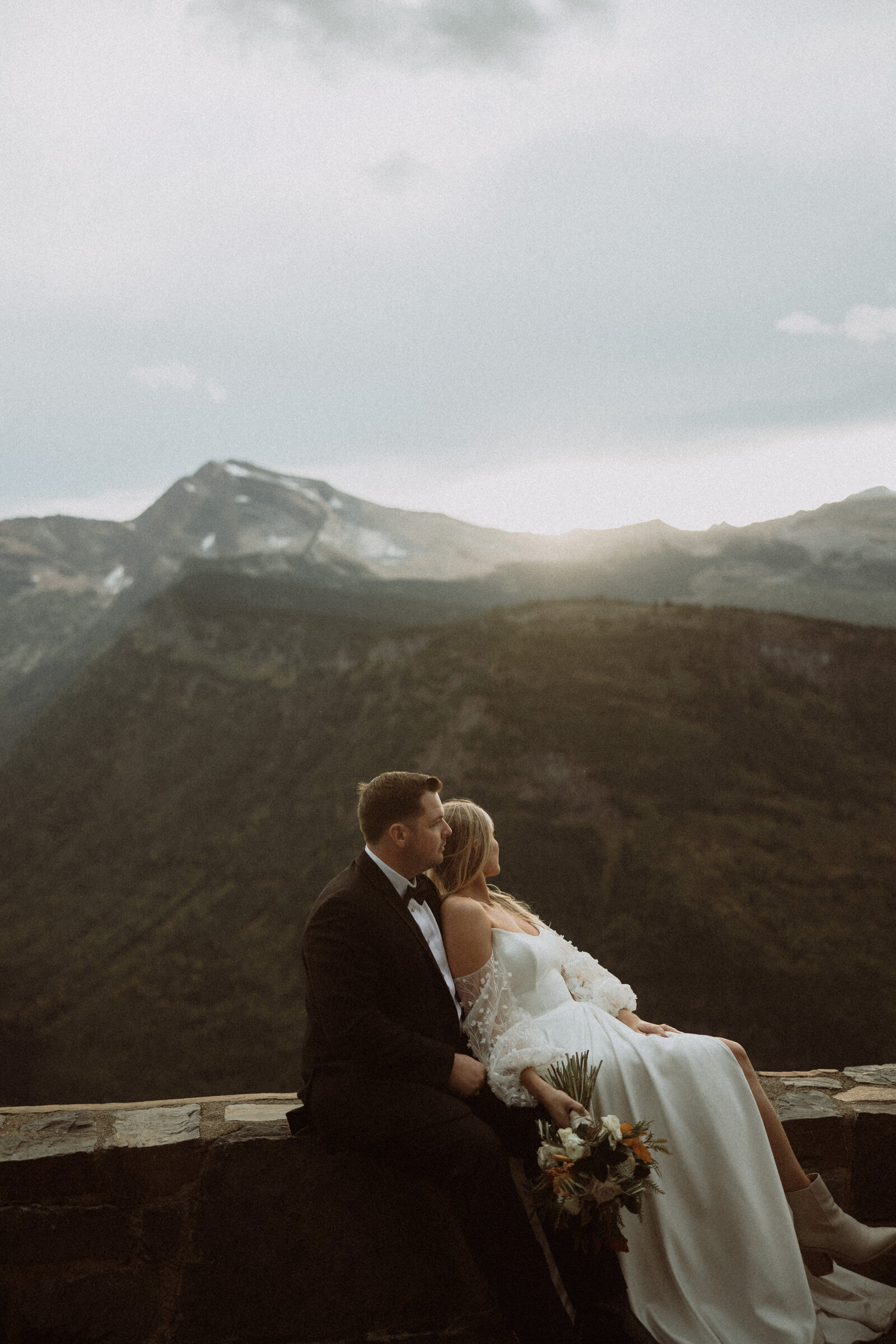couple sitting on ledge during their montana adventure elopement