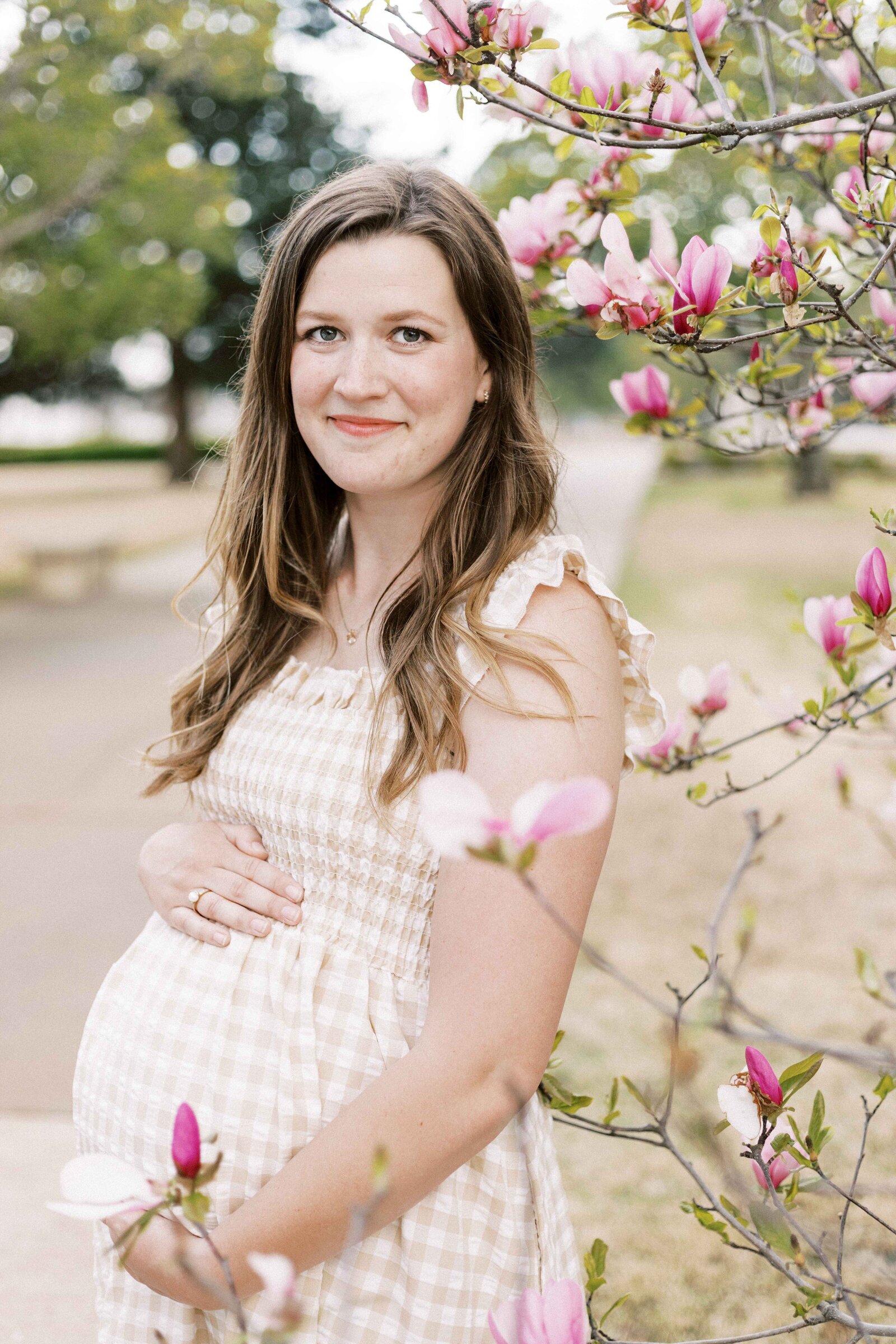 mom surrounded by magnolia blossoms during maternity photos in peoria illinois 