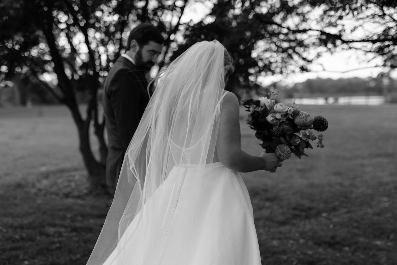 A bride with a flowing veil walks away