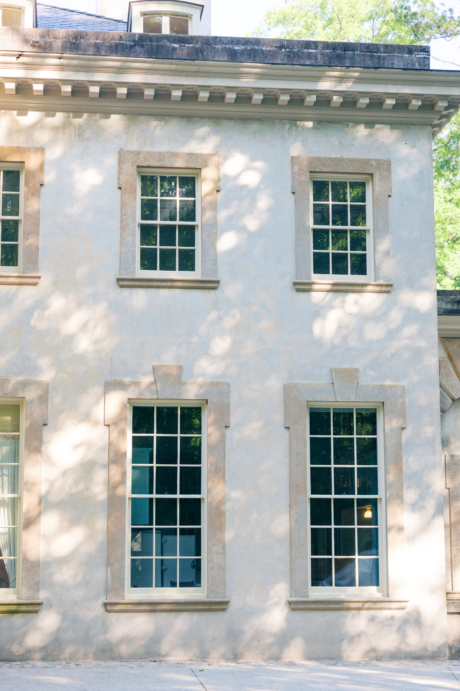 Speckled morning light on side of Swan House with windows