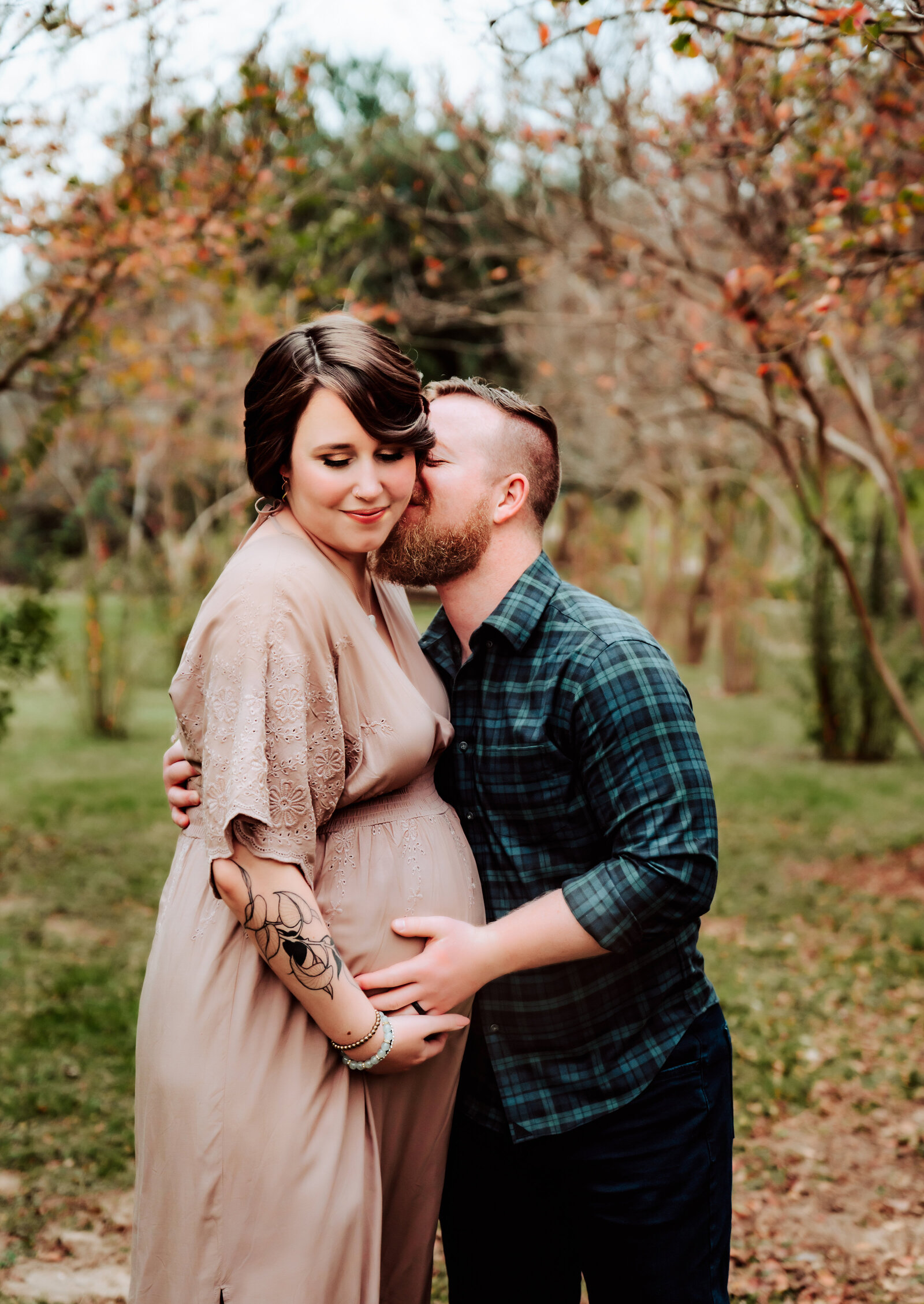 Maternity Photographer, a husband kisses his pregnant wife outdoors