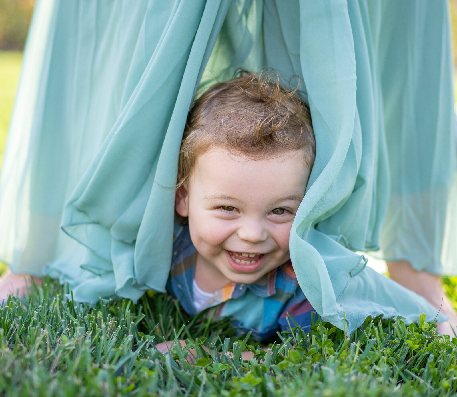 18-month-old Lincoln giggles as his mom flutters her dress around him in Columbus, Ohio.