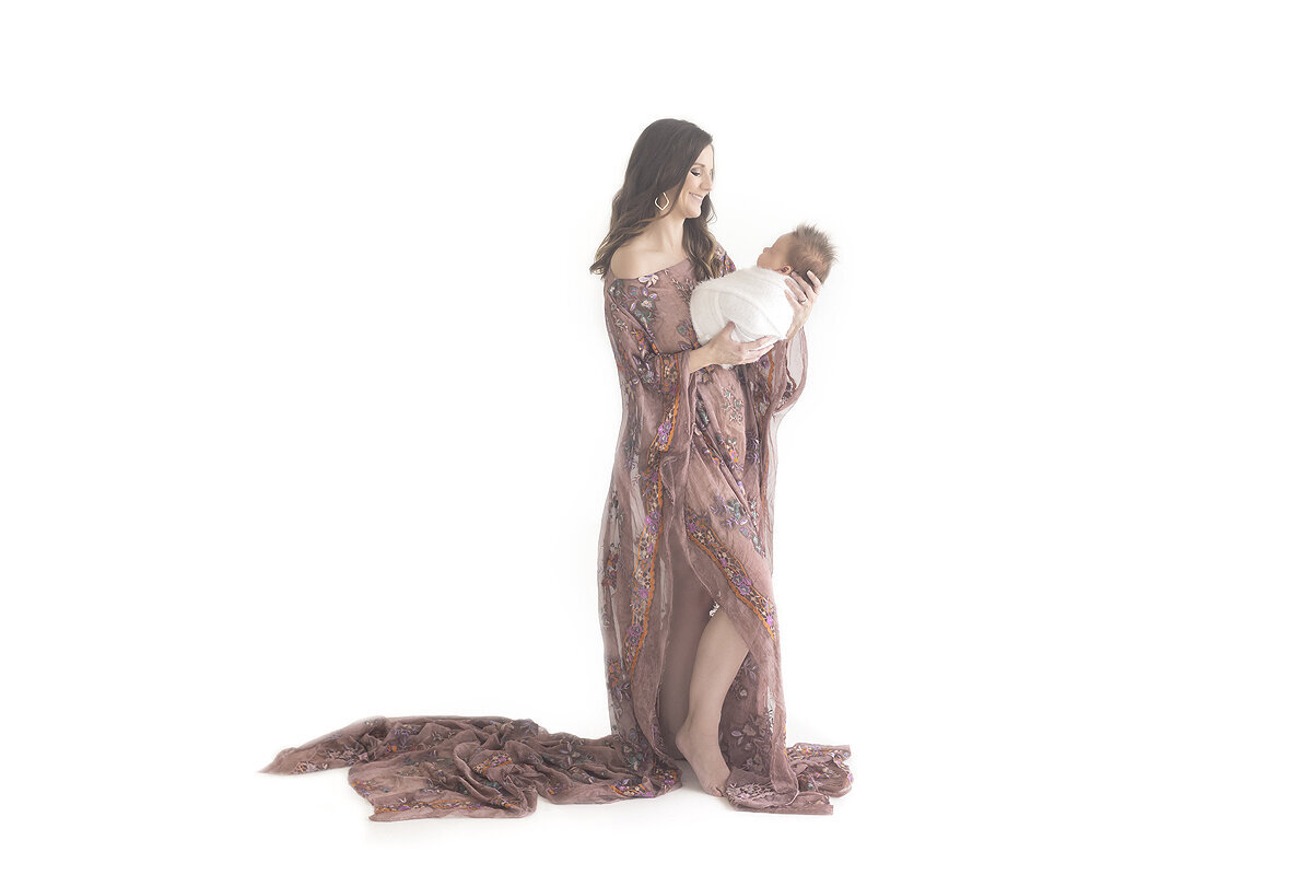 Mother holding newborn baby, a Dallas newborn photographer.