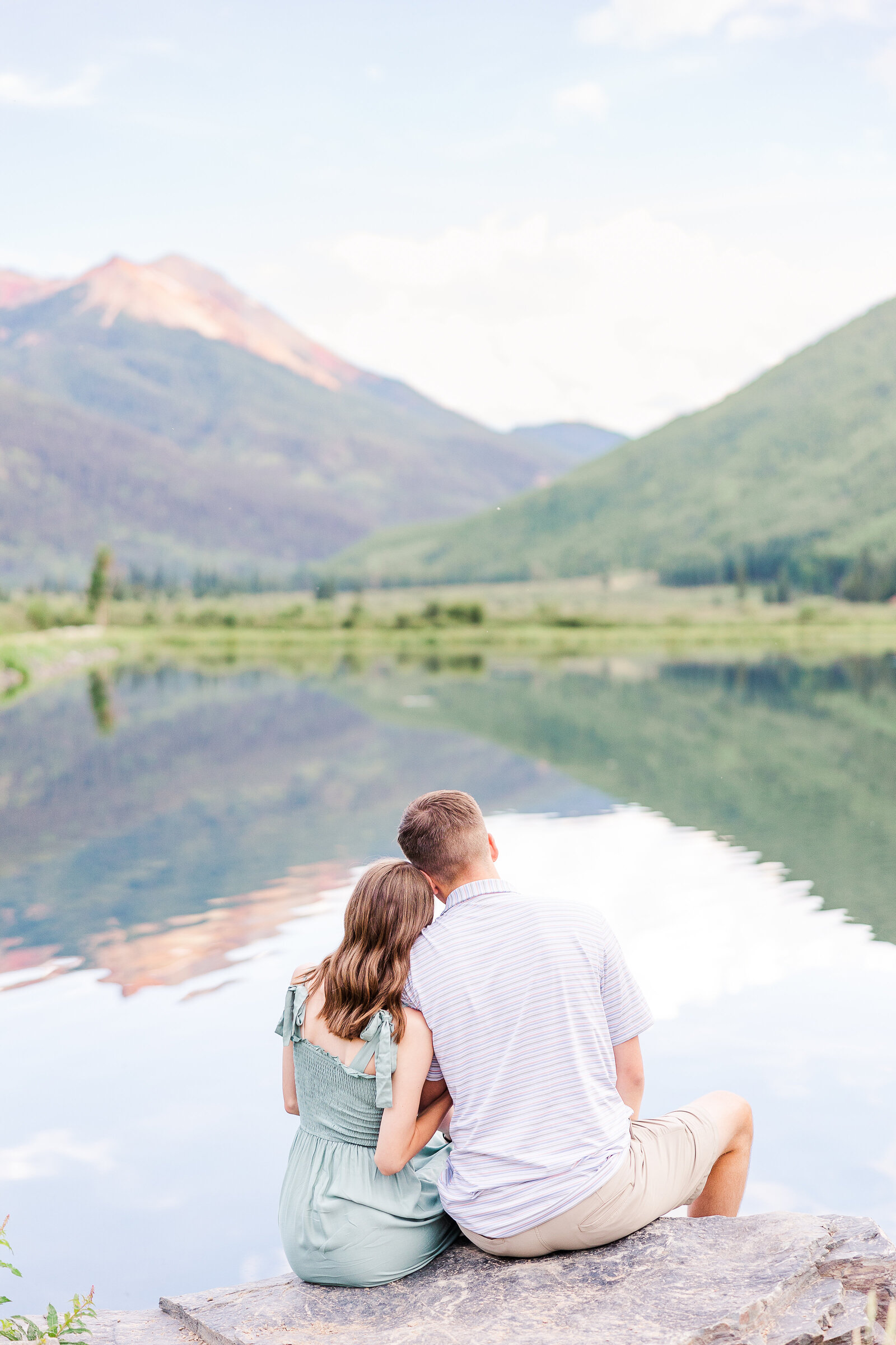 young couple face the lake