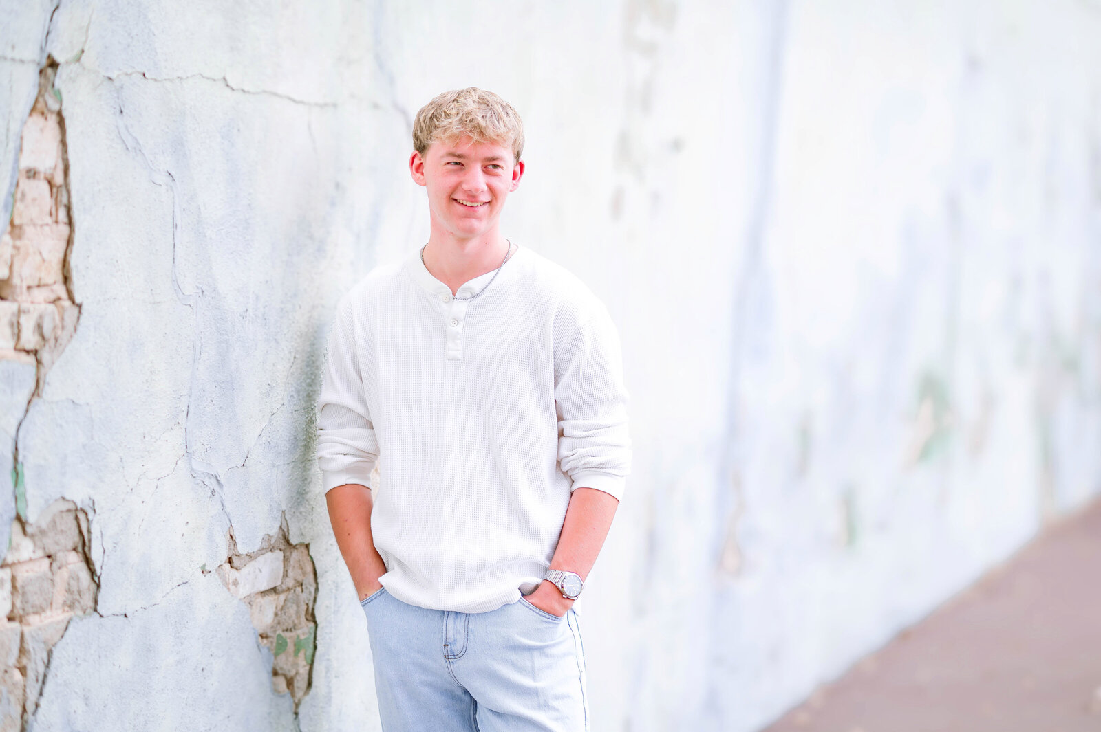 High school senior in a white shirt posing outdoors with soft natural light in McKinney, Texas, photographed by Jennifer L. Kirk Photography.
