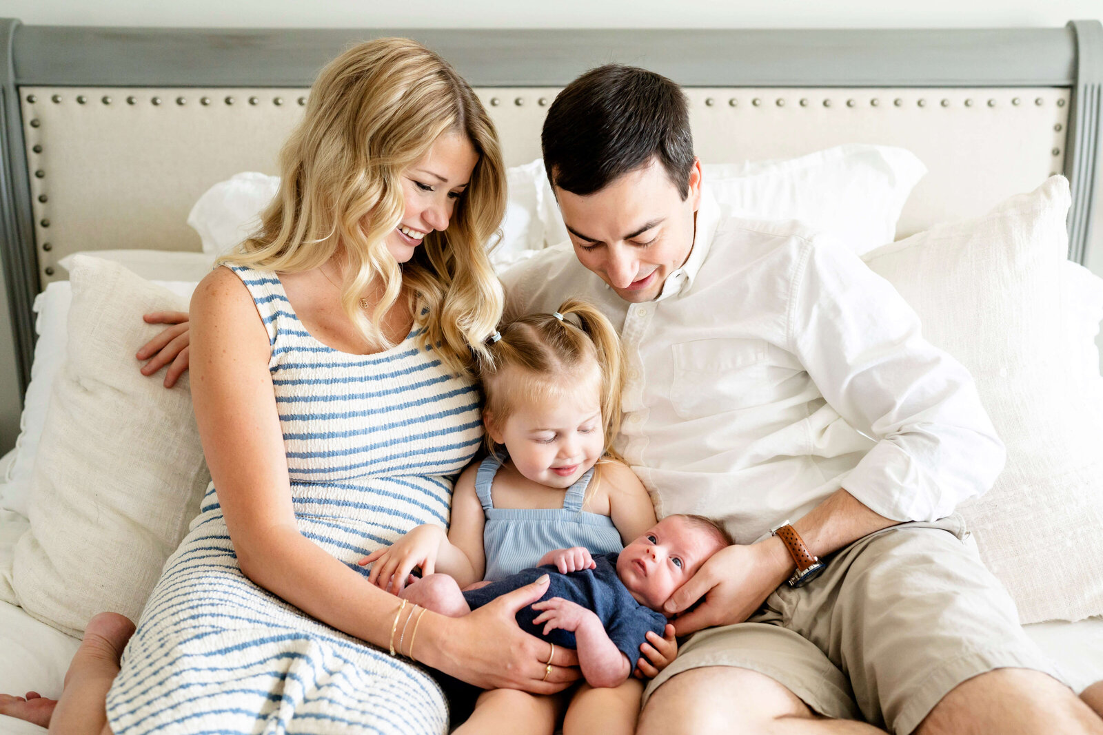 Family Photography for Atlanta, Parents, toddler and newborn smiling at each other in bed