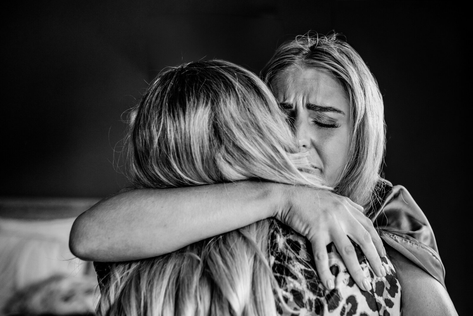An emotional woman hugging a bride.