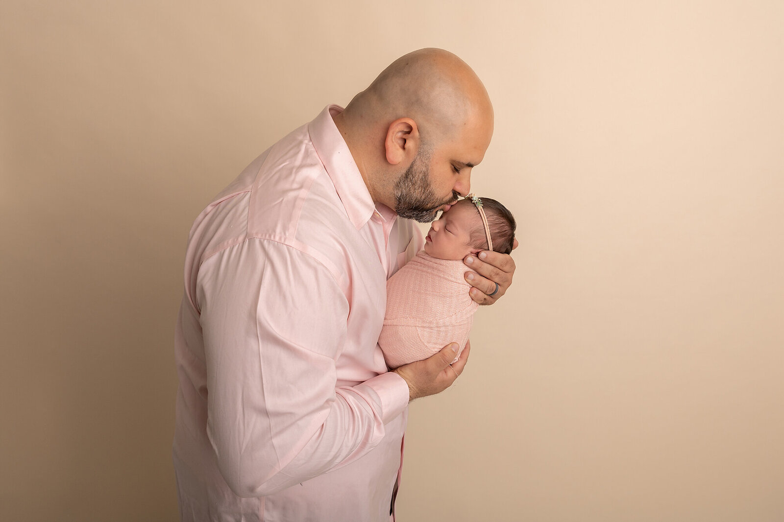 dad kissing newborn baby girl