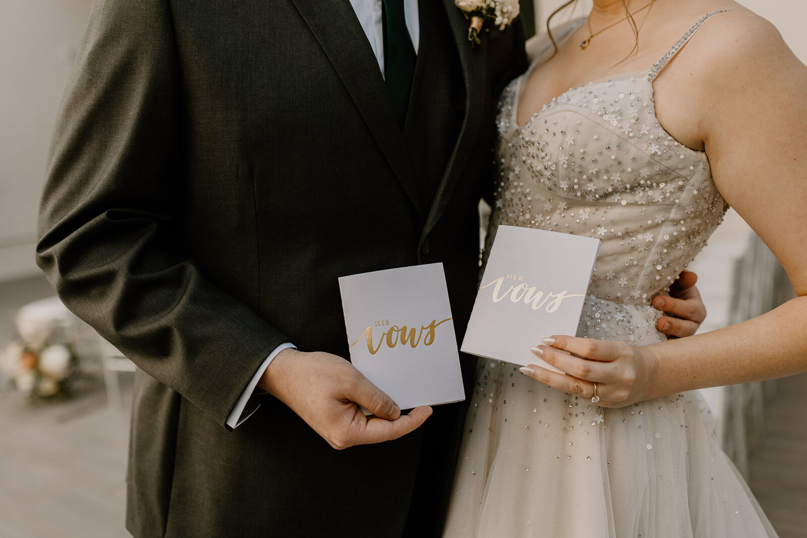 A bride and groom holding up wedding invitations.