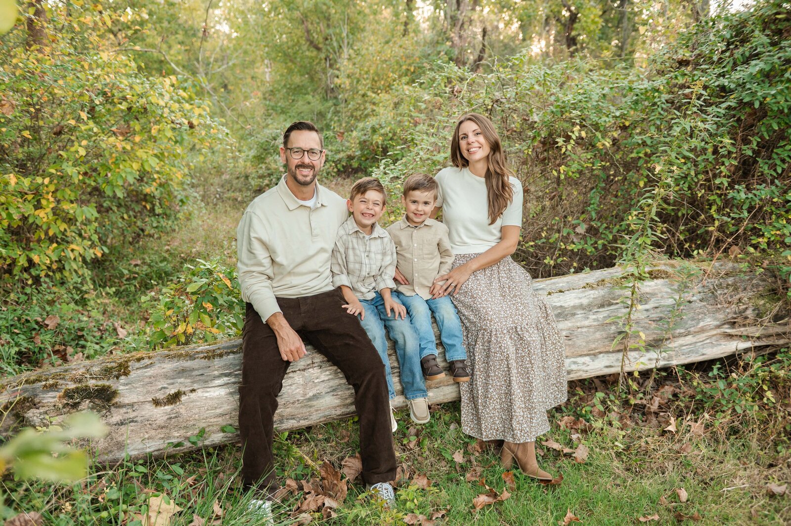 Family sitting on fallen tree during a relaxed Baltimore family photography session.