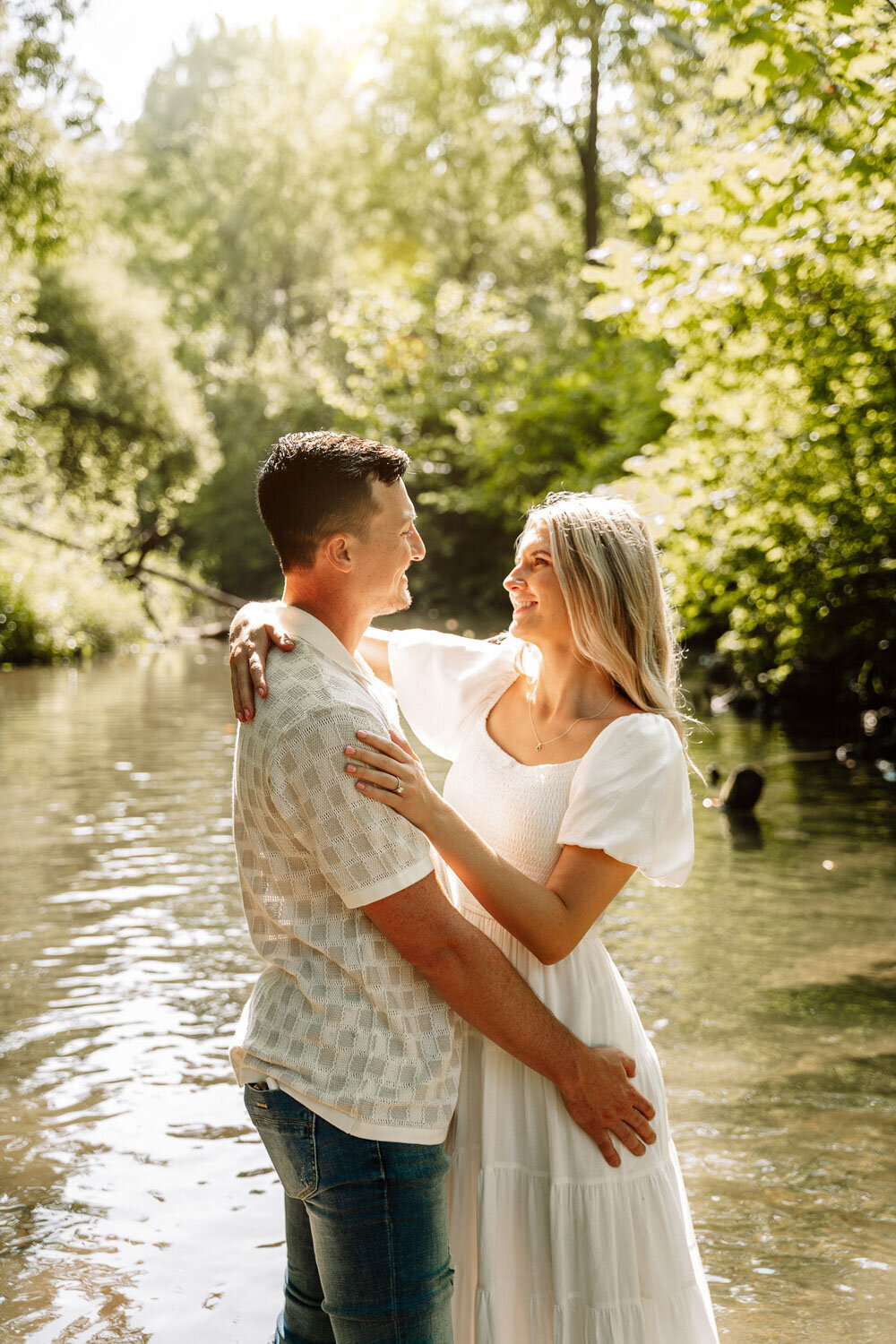 Bride and groom embracing in front of a warmly lit barn entrance