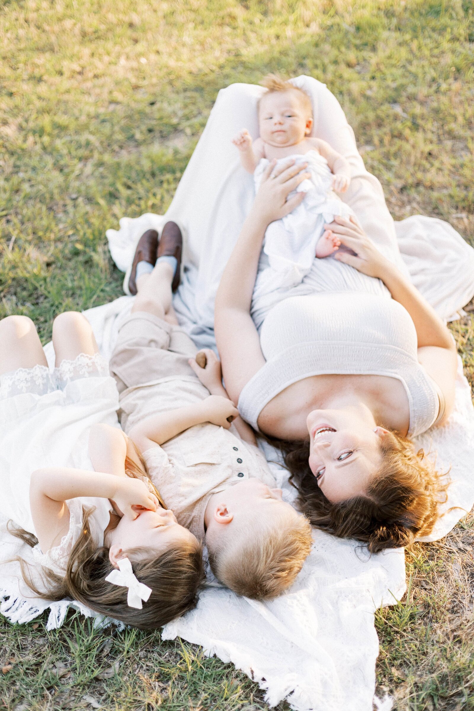 mom laying with children on blanket in peoria illinois newborn photos 