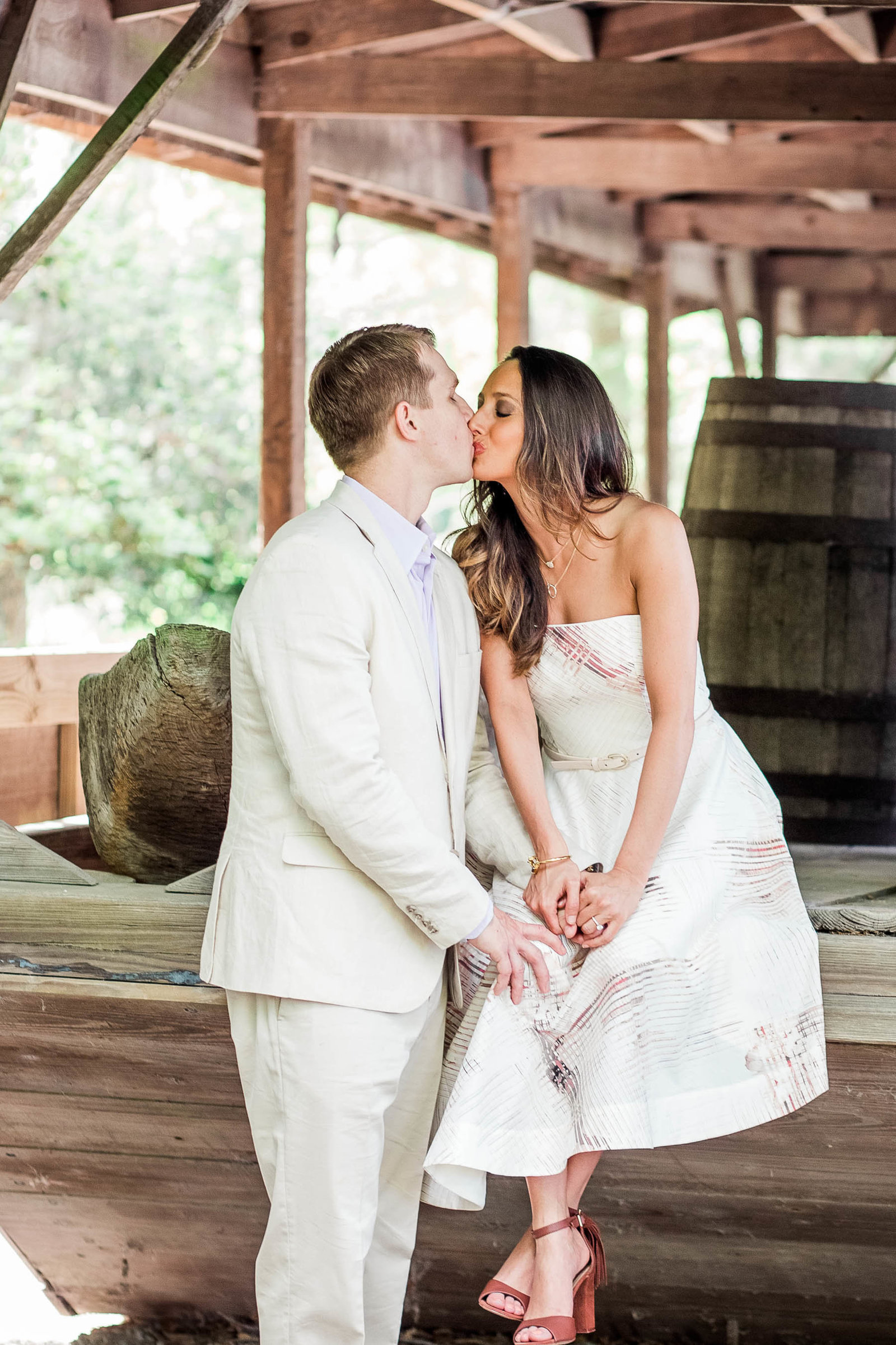 Engaged couple pose by old boat and barrels, Magnolia Plantation, Charleston, South Carolina