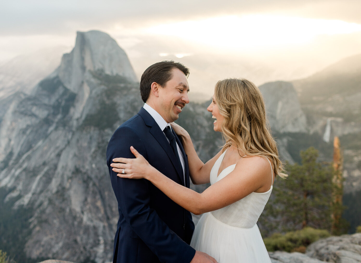 A bride and groom see each other for the first time during a yosemite sunrise in view of Half Dome.