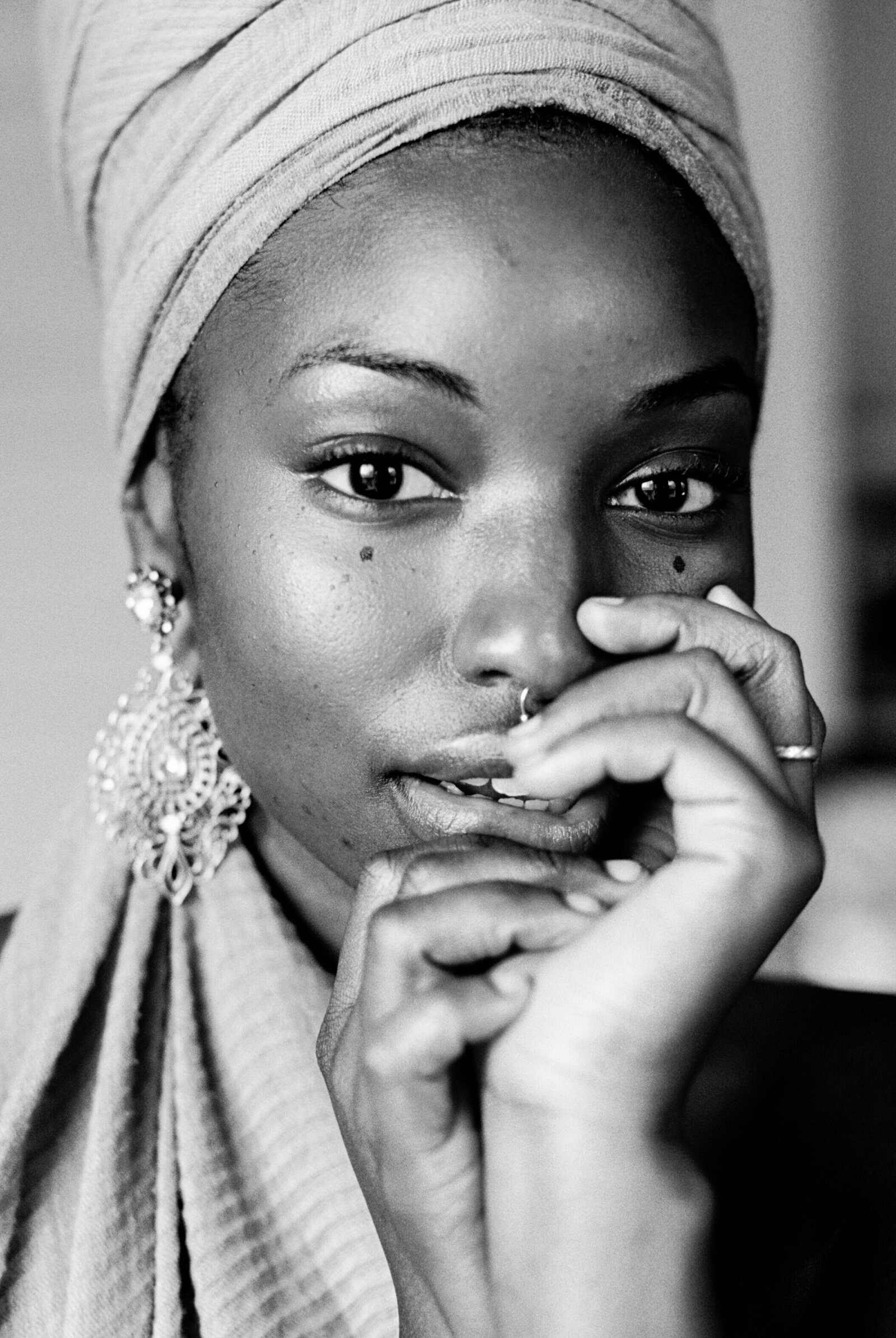 Black and white photo of a black woman wearing a headwrap and earrings