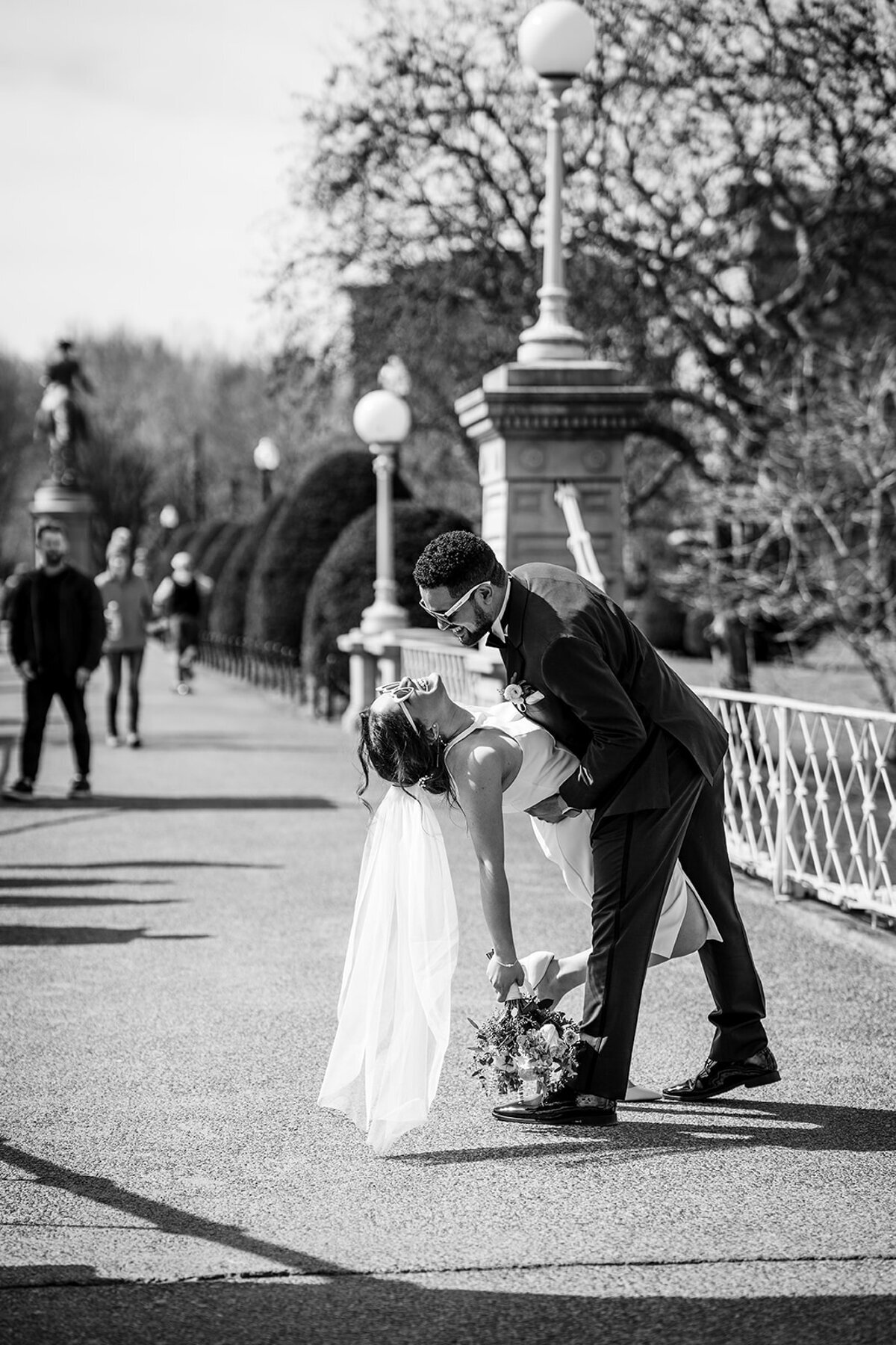 groom dips bride on bridge in boston public garden