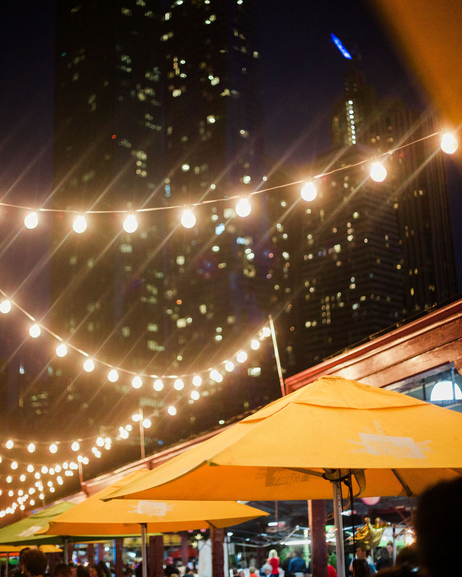 Branding travel tourism photographer Chelsea Loren captured Queen's Night Market in Melbourne Australia with twinkle ping pong lights and yellow umbrellas