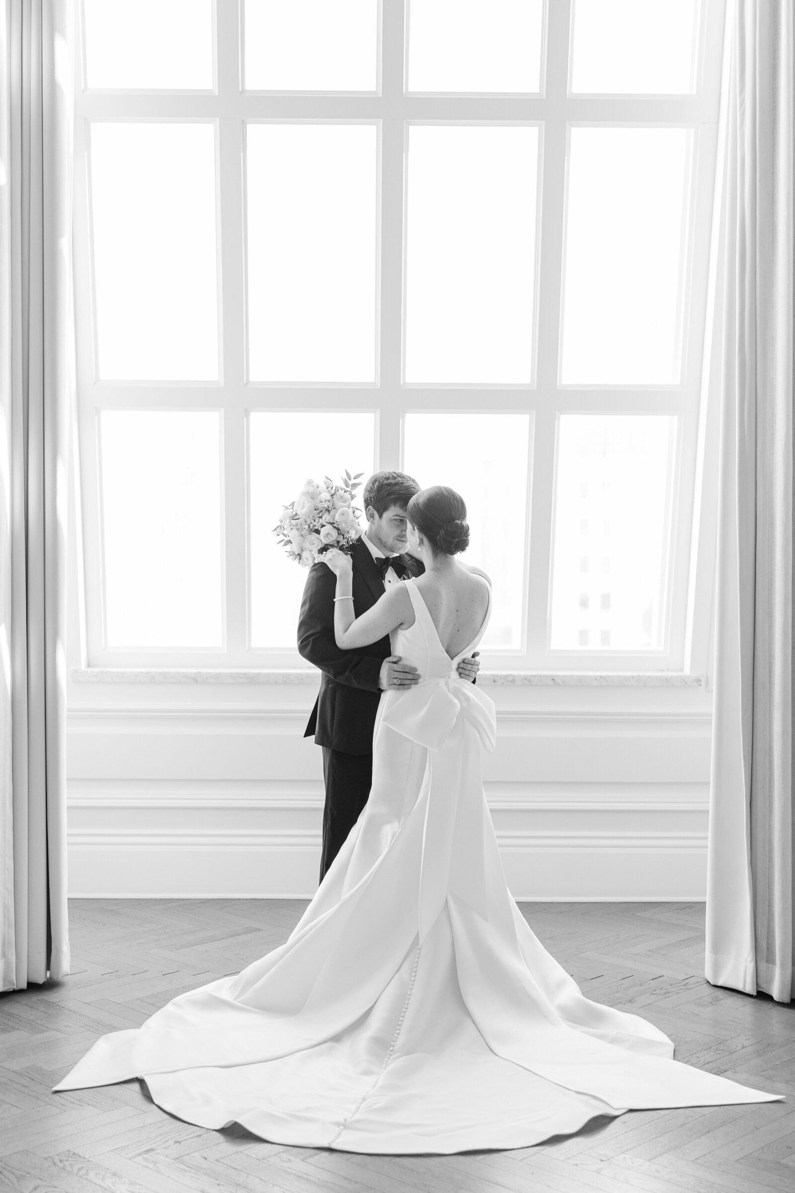 black-and-white-image-of -bride-and-groom-in-front-of-window