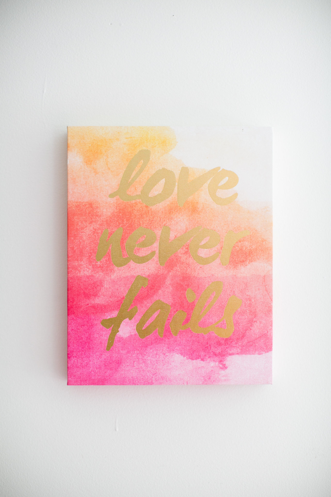 love never fails sign in gold lettering