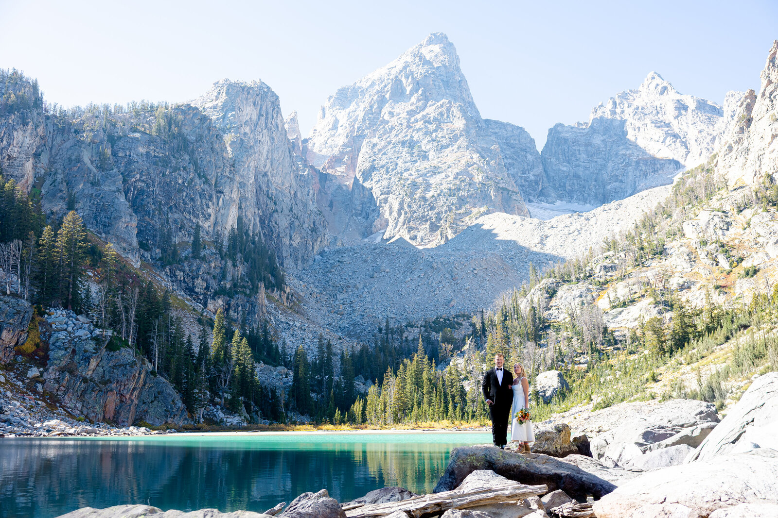Bridals wedding photography in the Grand Tetons. The bride and groom and looking into each others eyes and smiling with the Tetons behind them.