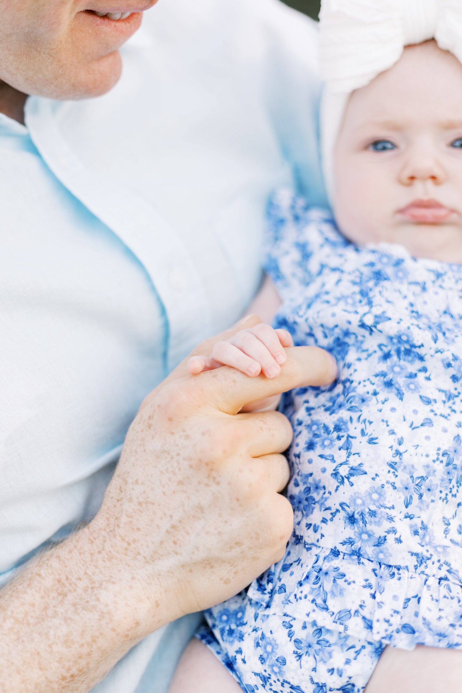 dad holding baby's hand during peoria illinois family photos 