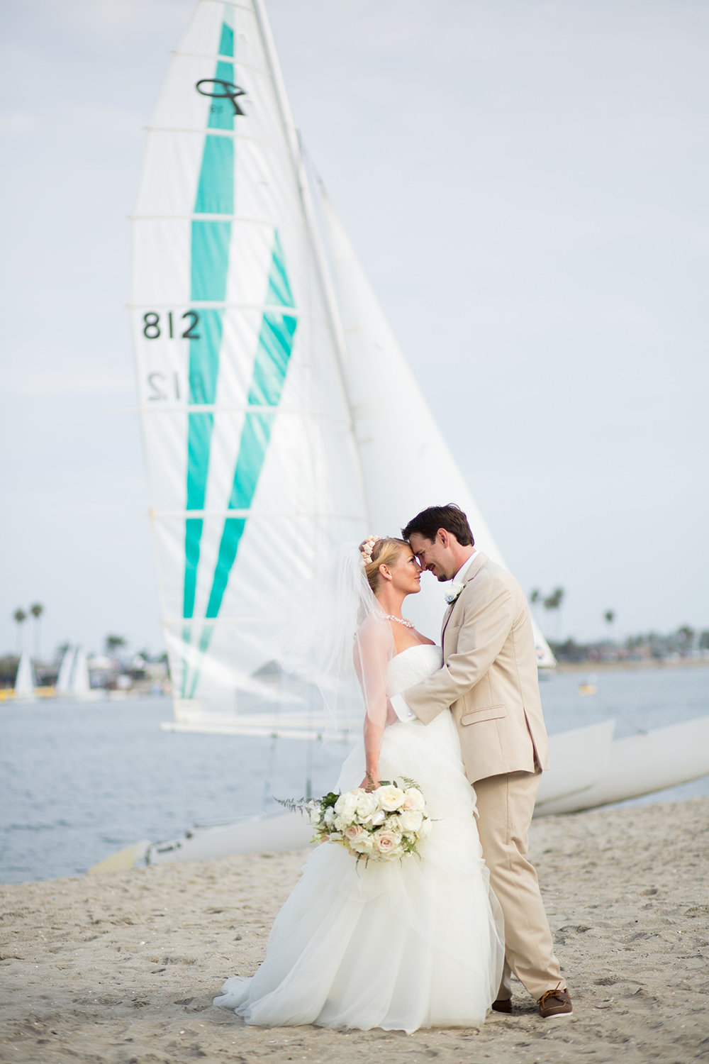 couple kissing with sailboat in the background