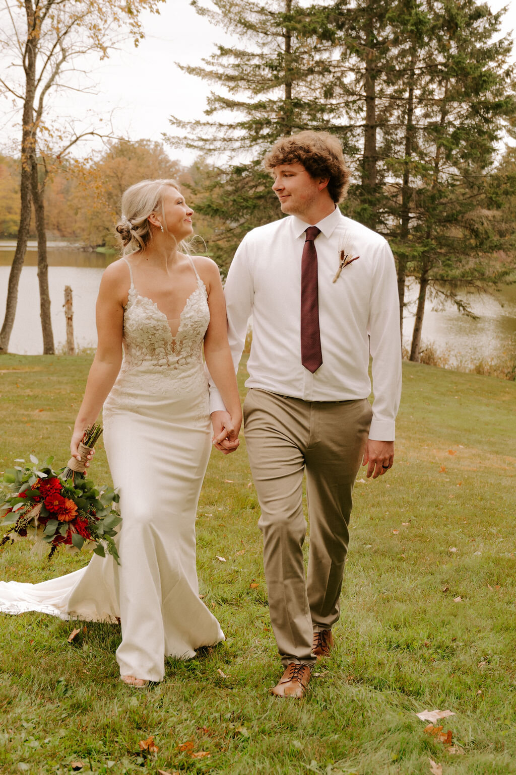 A bride and groom sharing a special moment on the Echo Valley property, with a lake and wooded backdrop.