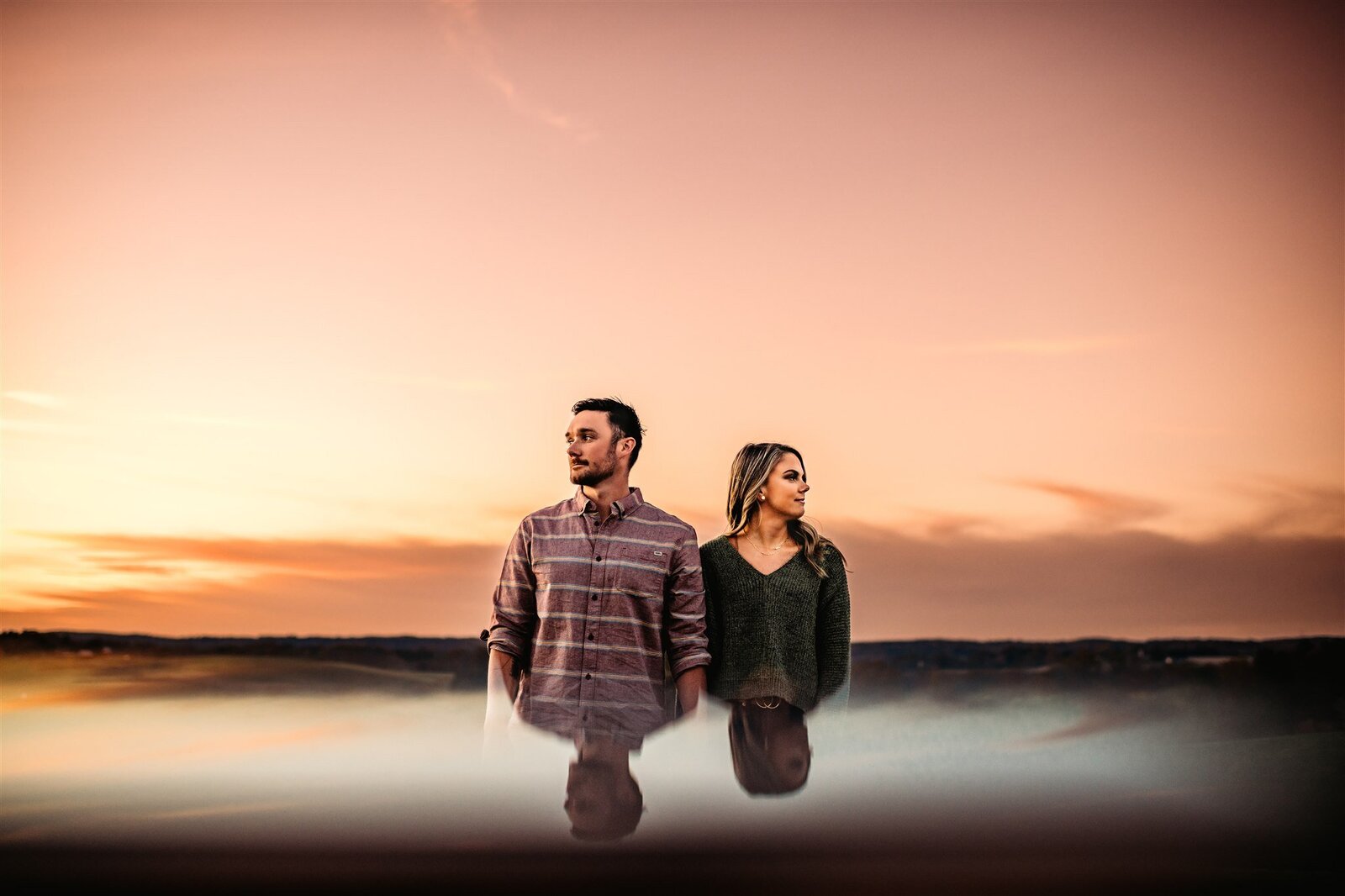 Unique engagement photos with man and woman standing together looking opposite ways with a clear sky at sunset captured by Baltimore photographers